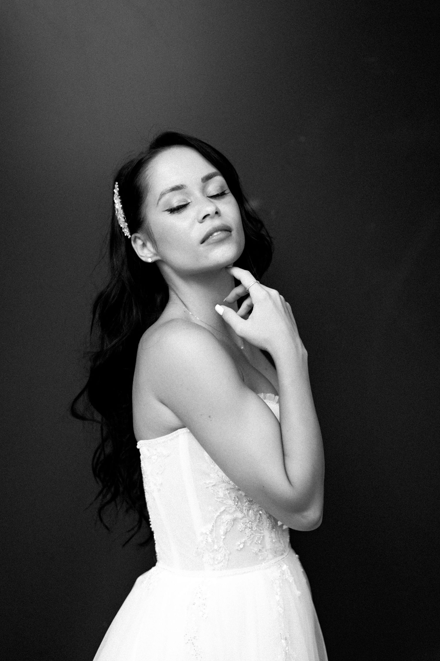 Elegant bridal portrait in black and white showing a woman in a strapless wedding gown.