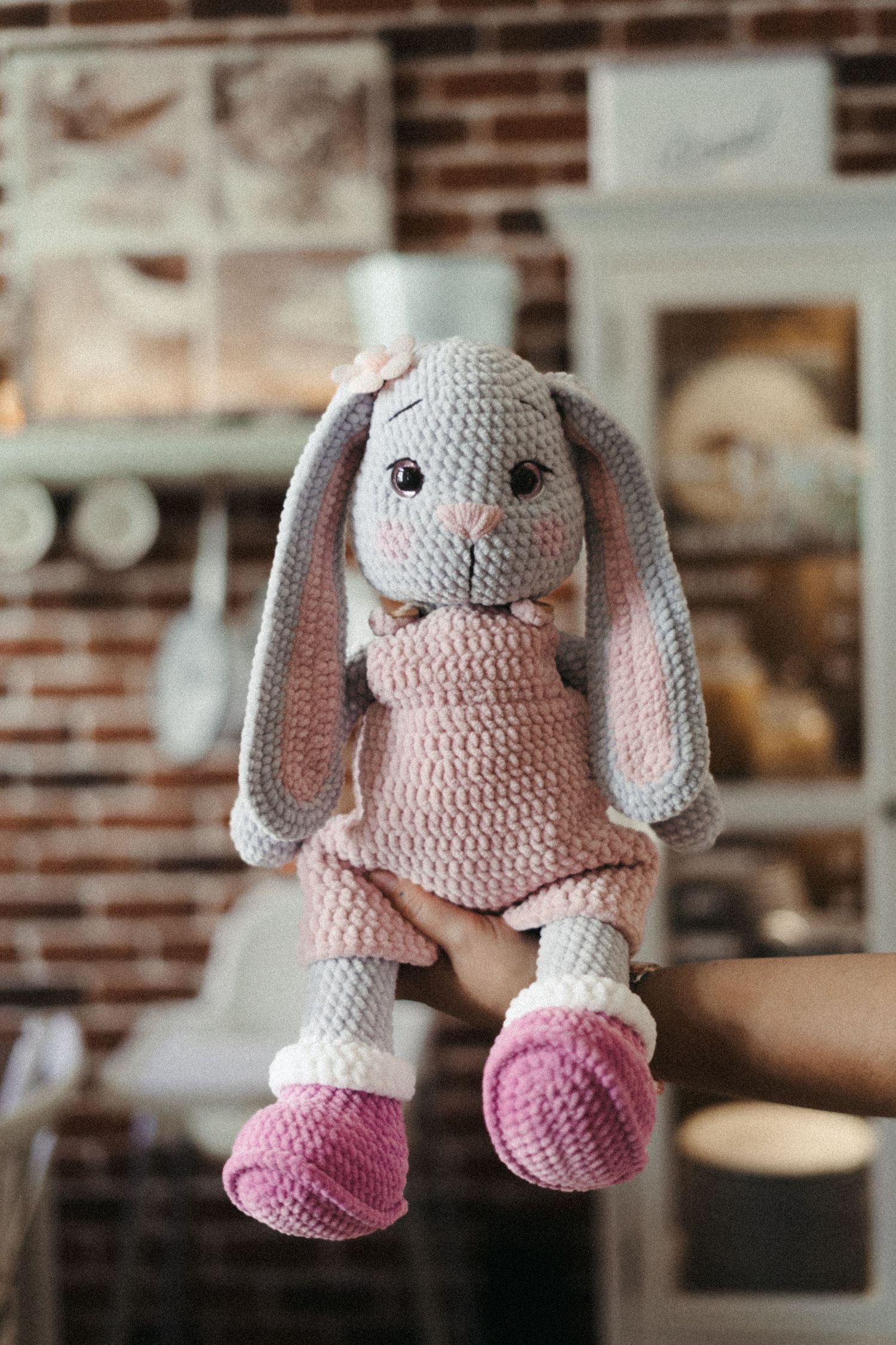 A cute pink and gray crocheted bunny amigurumi toy shown from different angles in a sequence of photos.