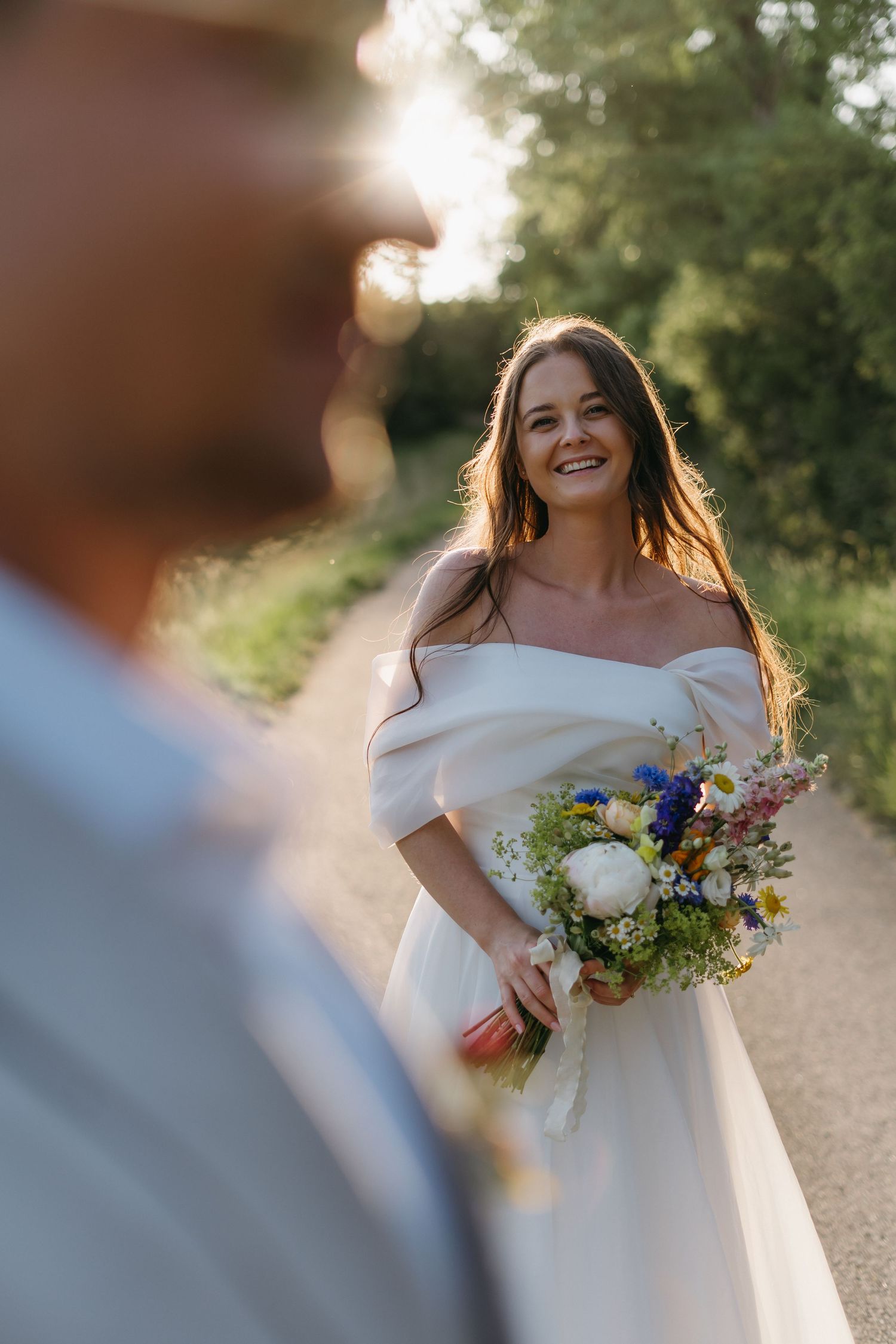 A wedding scene capturing a radiant moment with white dress and colorful bouquet in golden sunlit setting.
