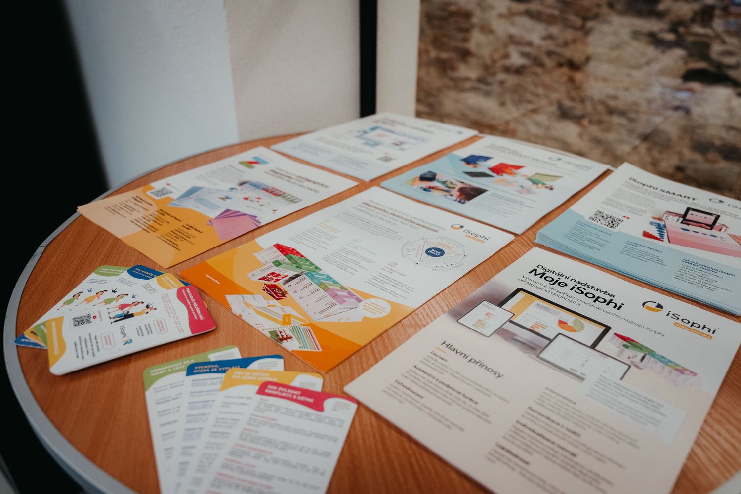 Educational materials and worksheets spread across tables during a training session.