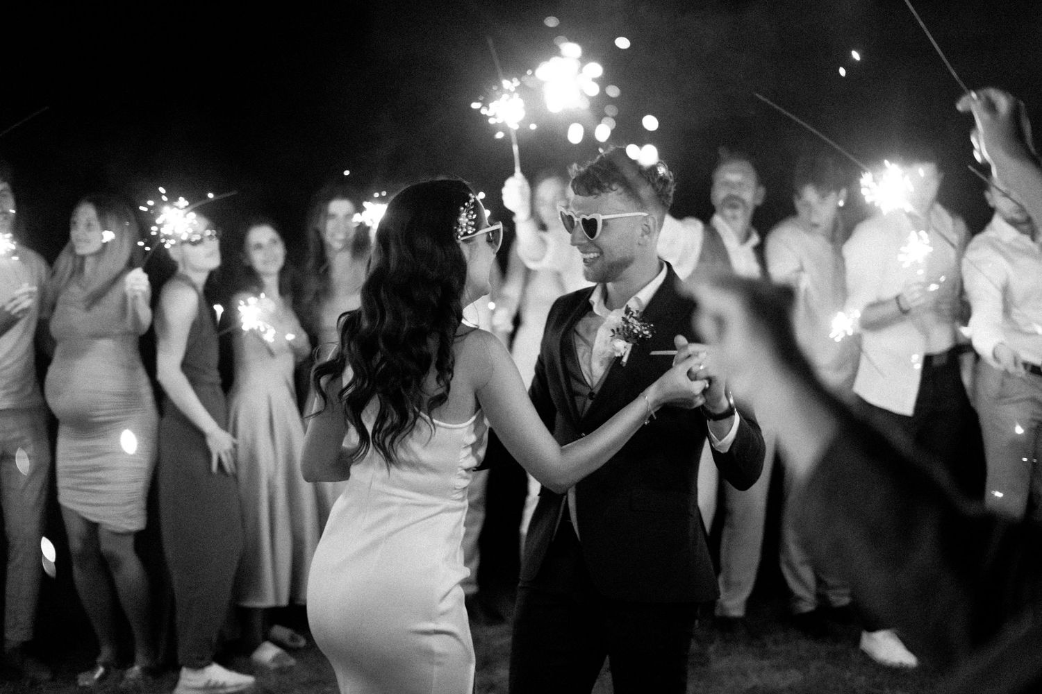 A collage of people dancing and celebrating at a festive party event with sparklers and lights.