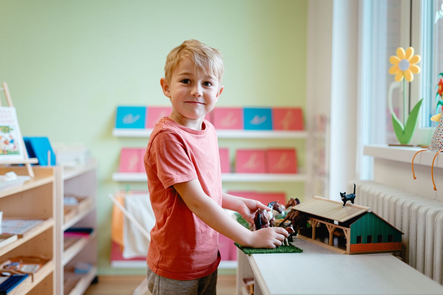 Young children play and learn in a bright, colorful classroom setting with educational materials and toys.