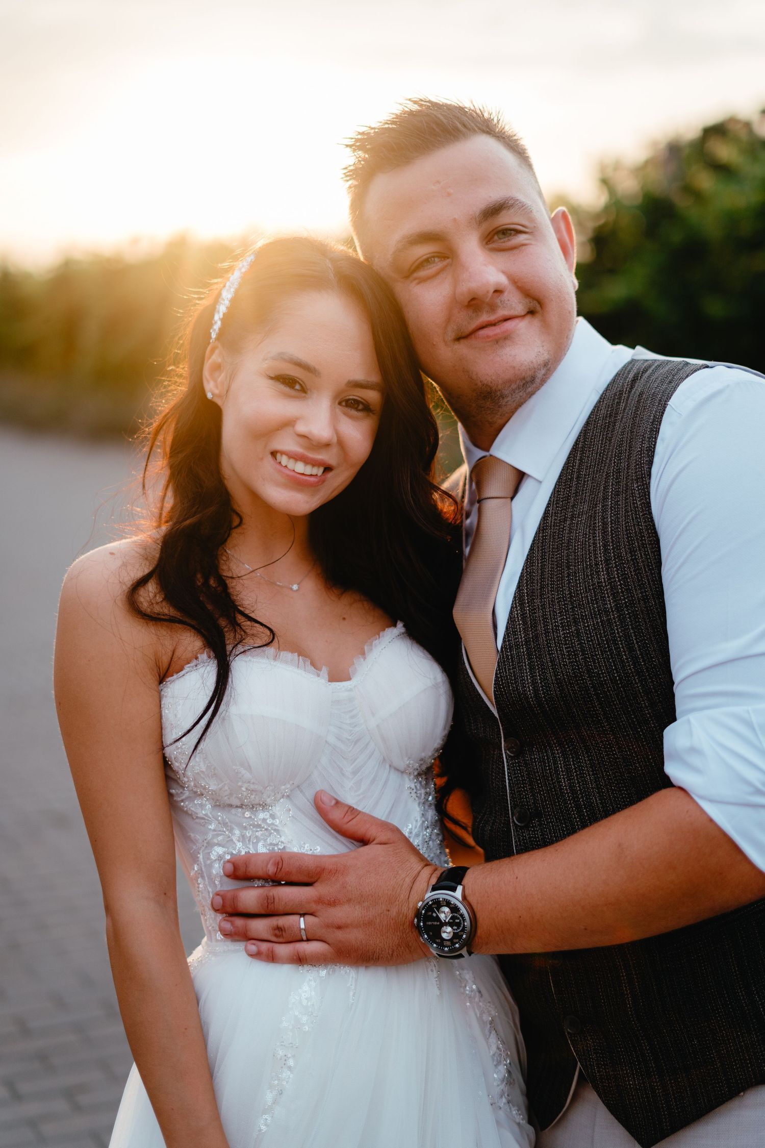 Romantic sunset portrait of newlyweds embracing outdoors.