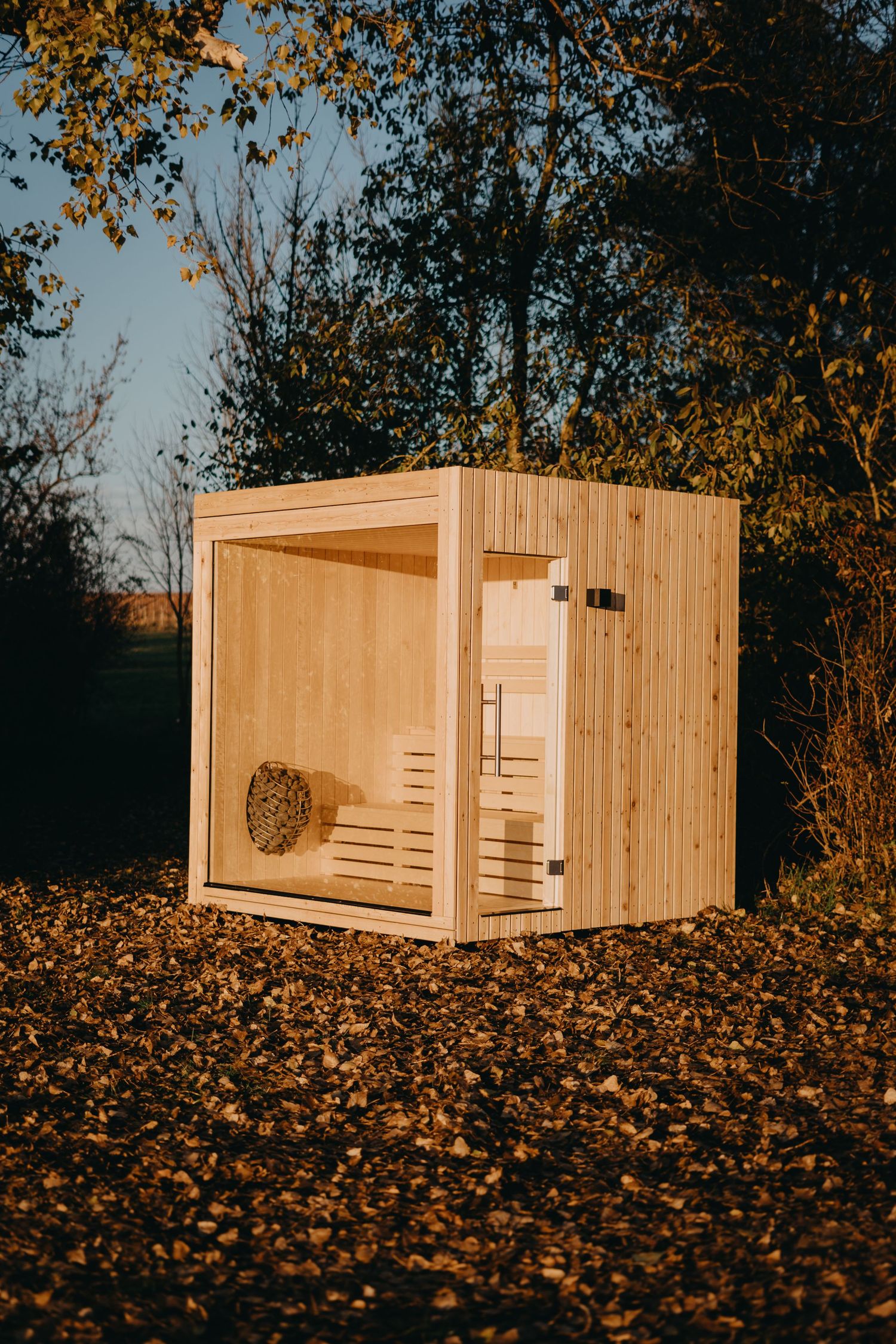 A wooden modular structure is photographed in sequence showing different angles against a backdrop of autumn leaves.