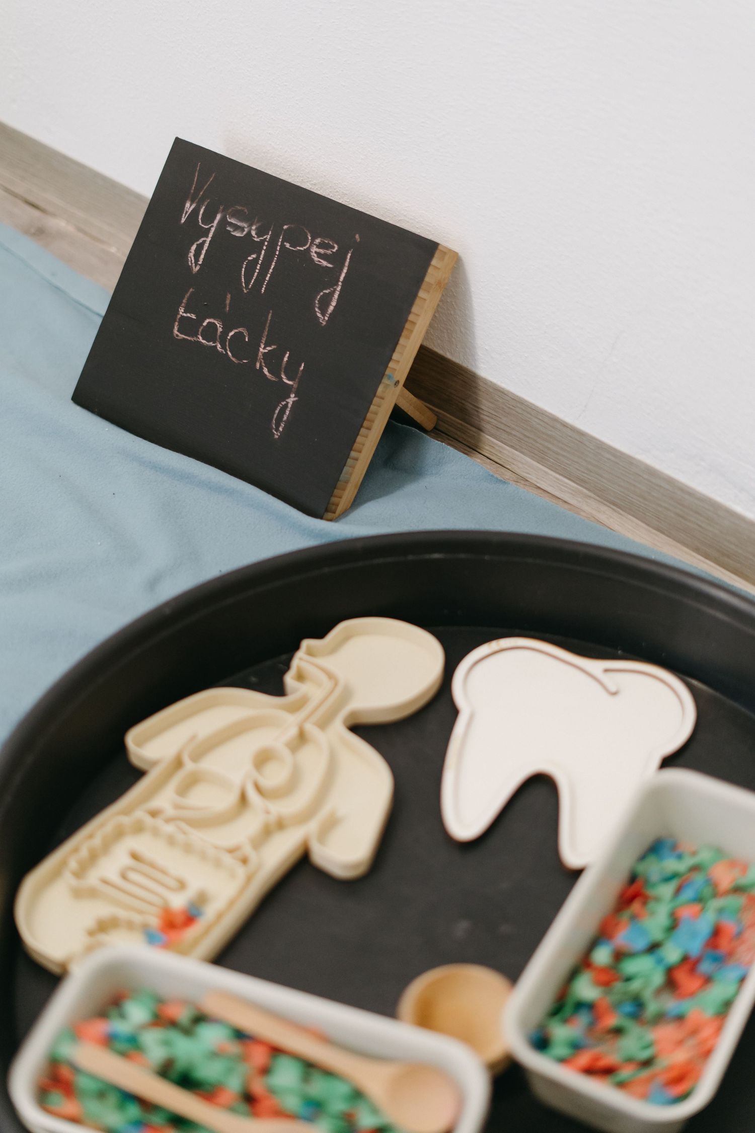 Four decorative sugar cookies laid out in a playful pattern on a dark surface with colorful sprinkles.