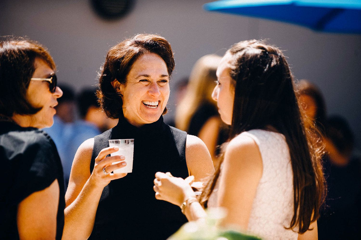 People enjoying drinks and conversation at a social gathering indoors.