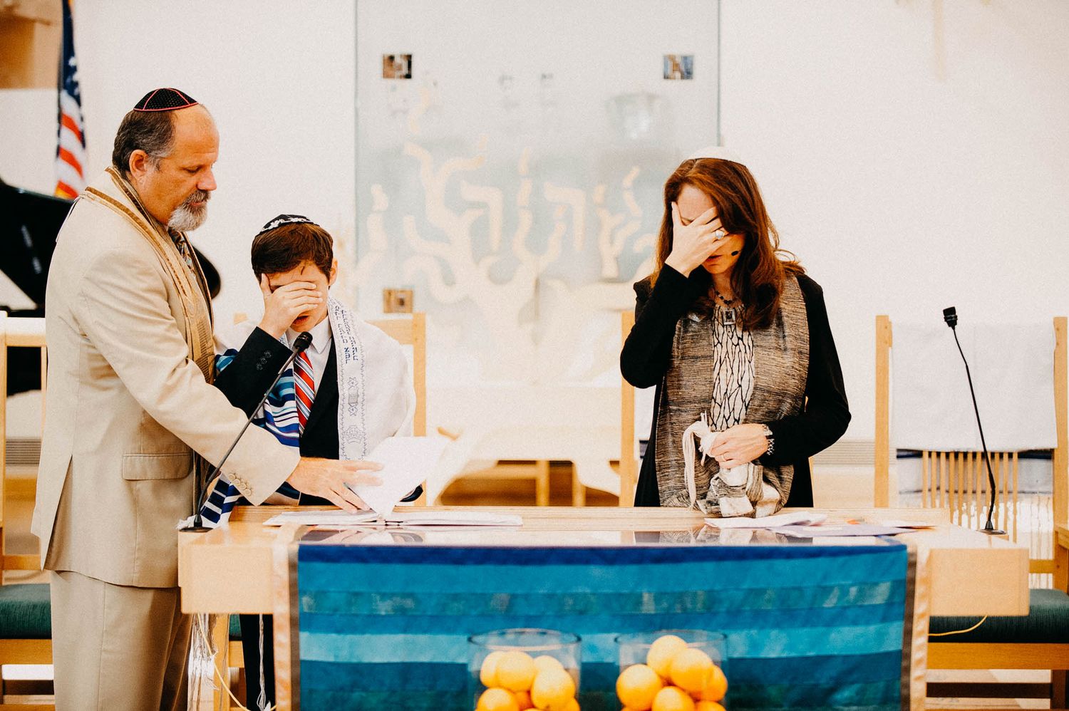 People gathered around a blue table during a religious ceremony.