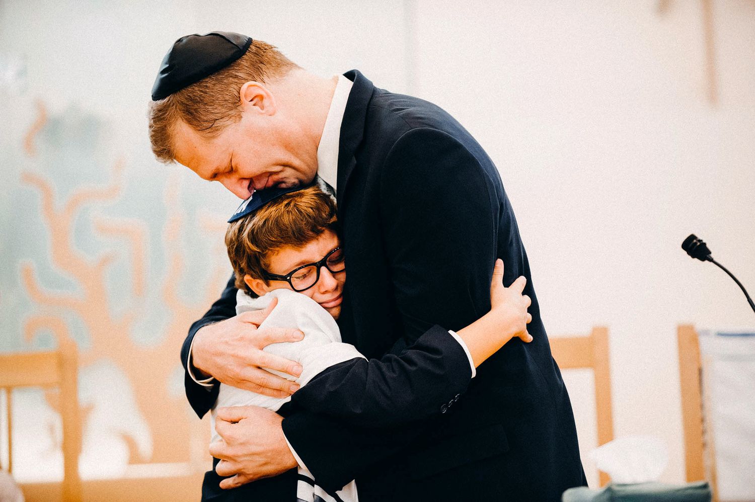 Two people sharing an emotional embrace during a formal ceremony.