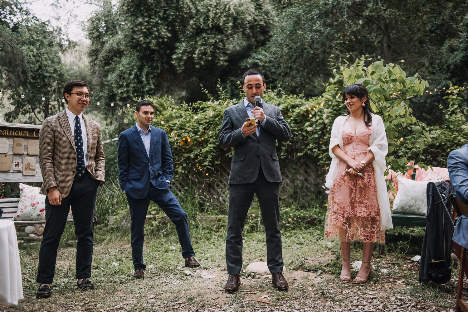 A group of well-dressed guests enjoying themselves at an outdoor garden party.