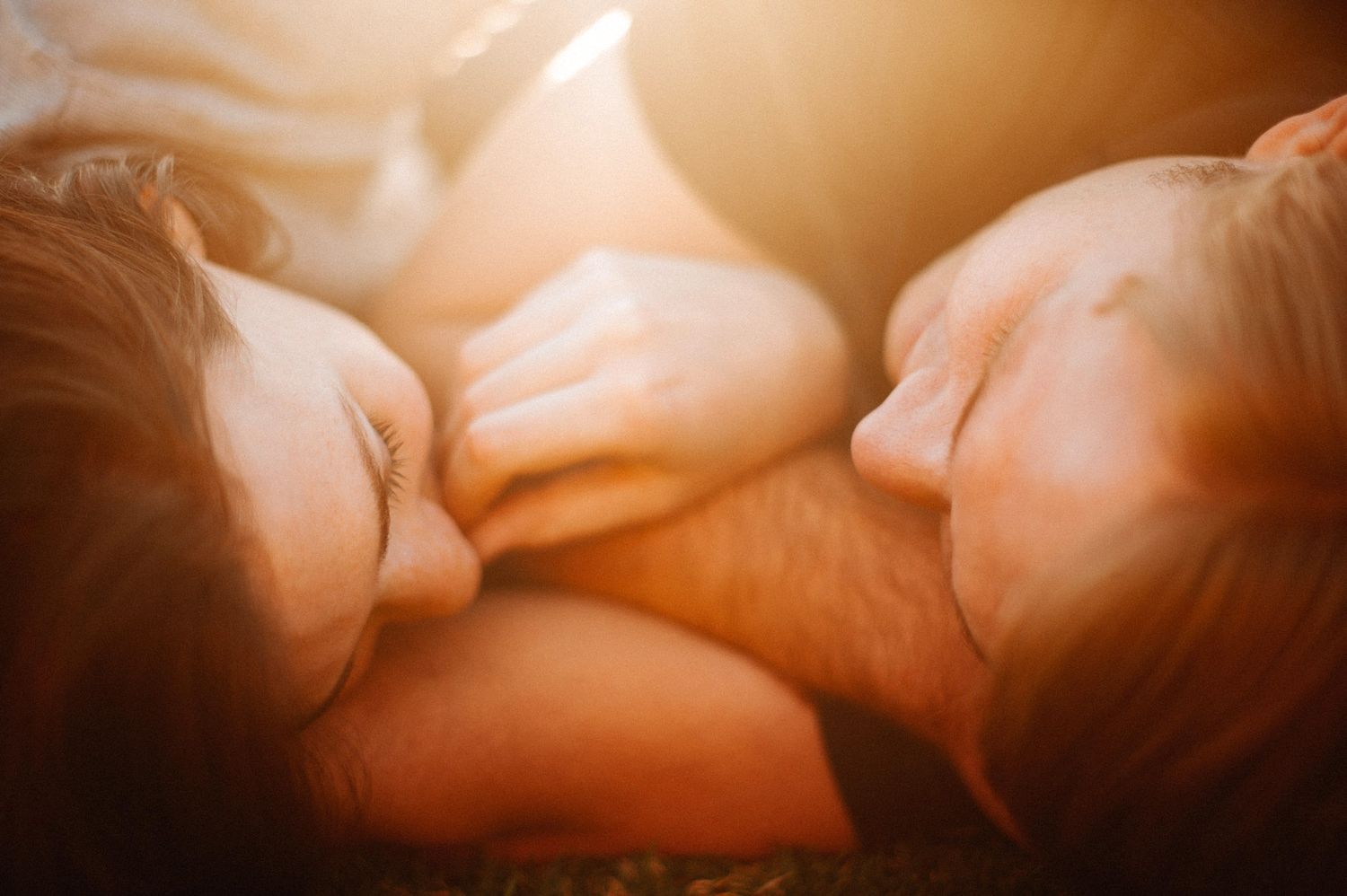 Intimate close-up portrait bathed in warm golden light capturing tender romantic moment.