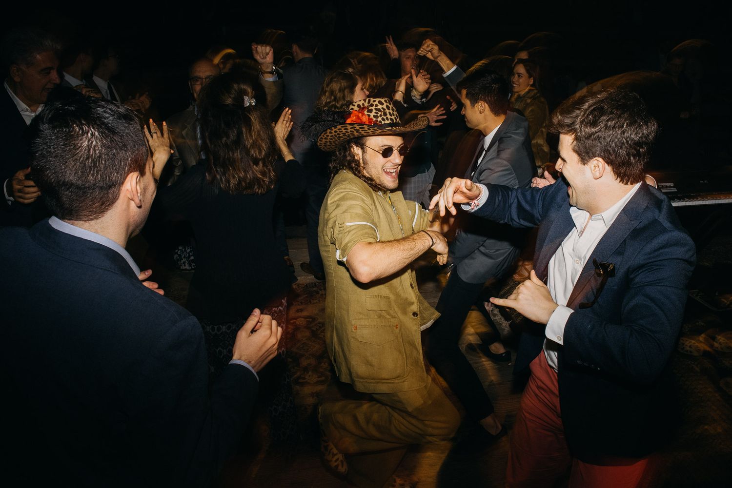 Dark nightclub scene with people dancing and socializing in a crowded space.