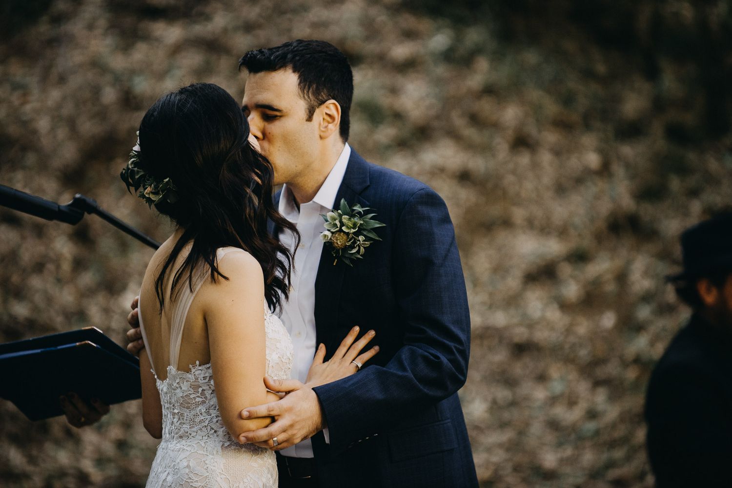 A romantic wedding couple shares intimate moments in a series of candid photos against a rustic outdoor backdrop.