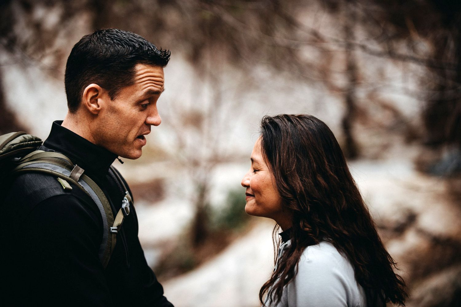 Close up of a couple gazing at each other against a blurred winter background.