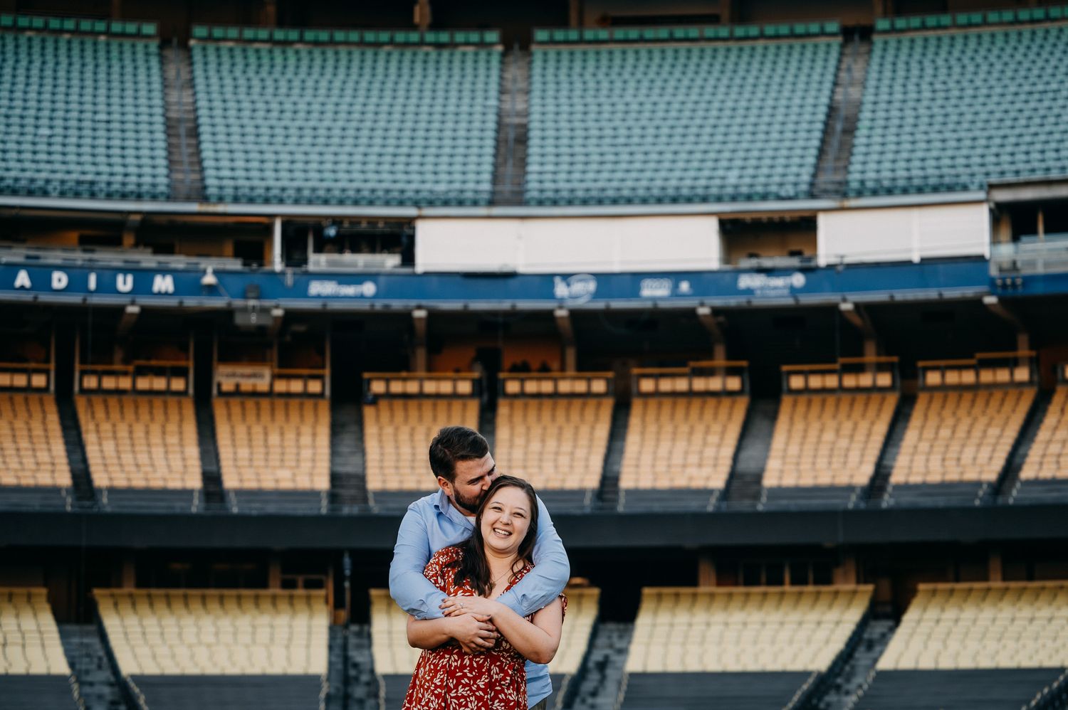 A couple shares an intimate moment in the empty stands of Dodger Stadium during a photo session.