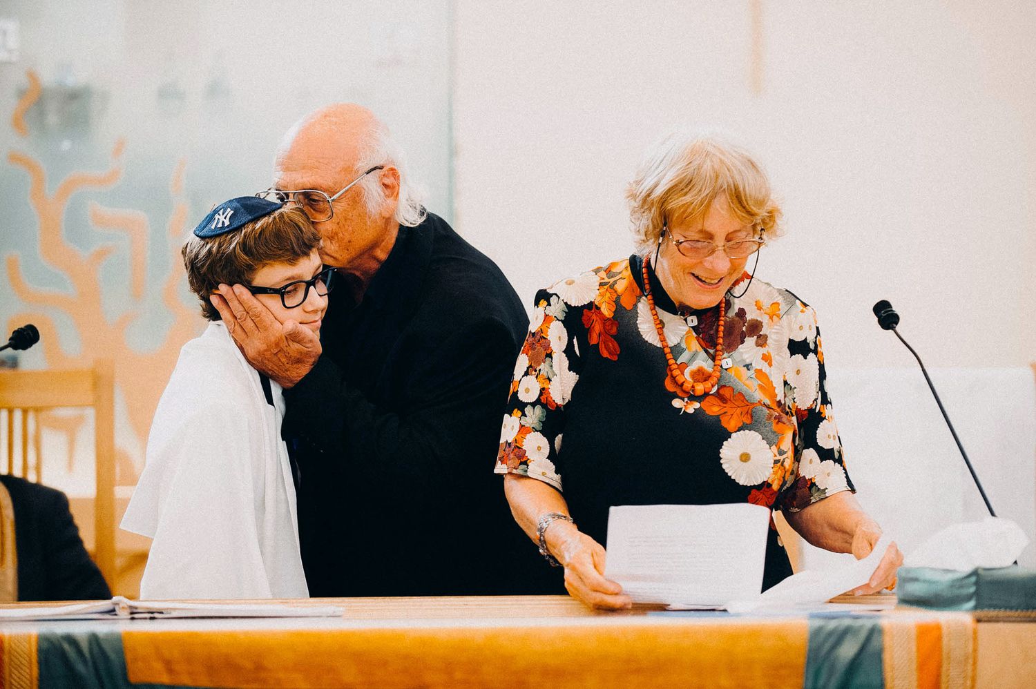 Three people seated at a podium during what appears to be a panel discussion or presentation.