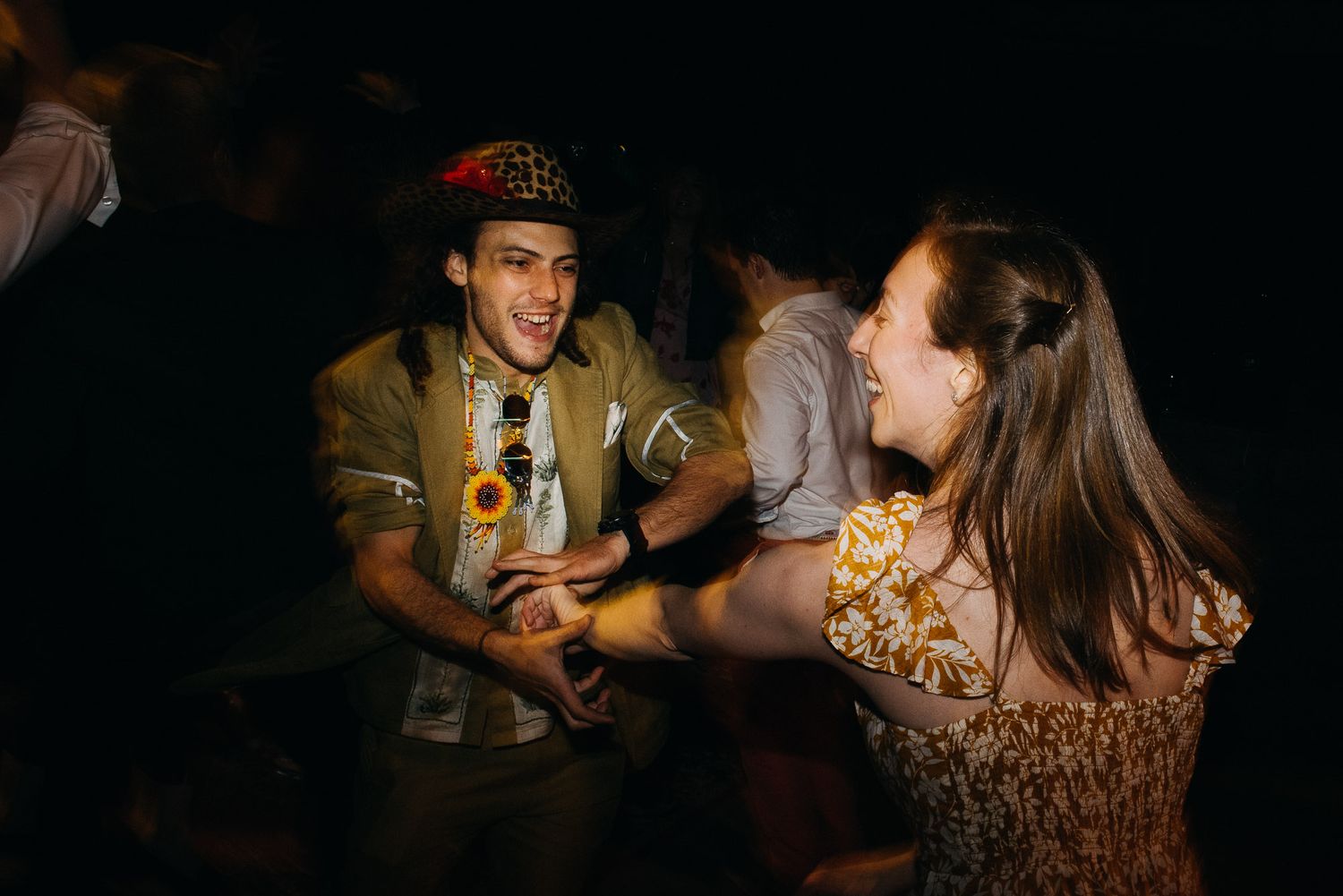 A group of people use flashlights to illuminate their activities in a dimly lit environment.