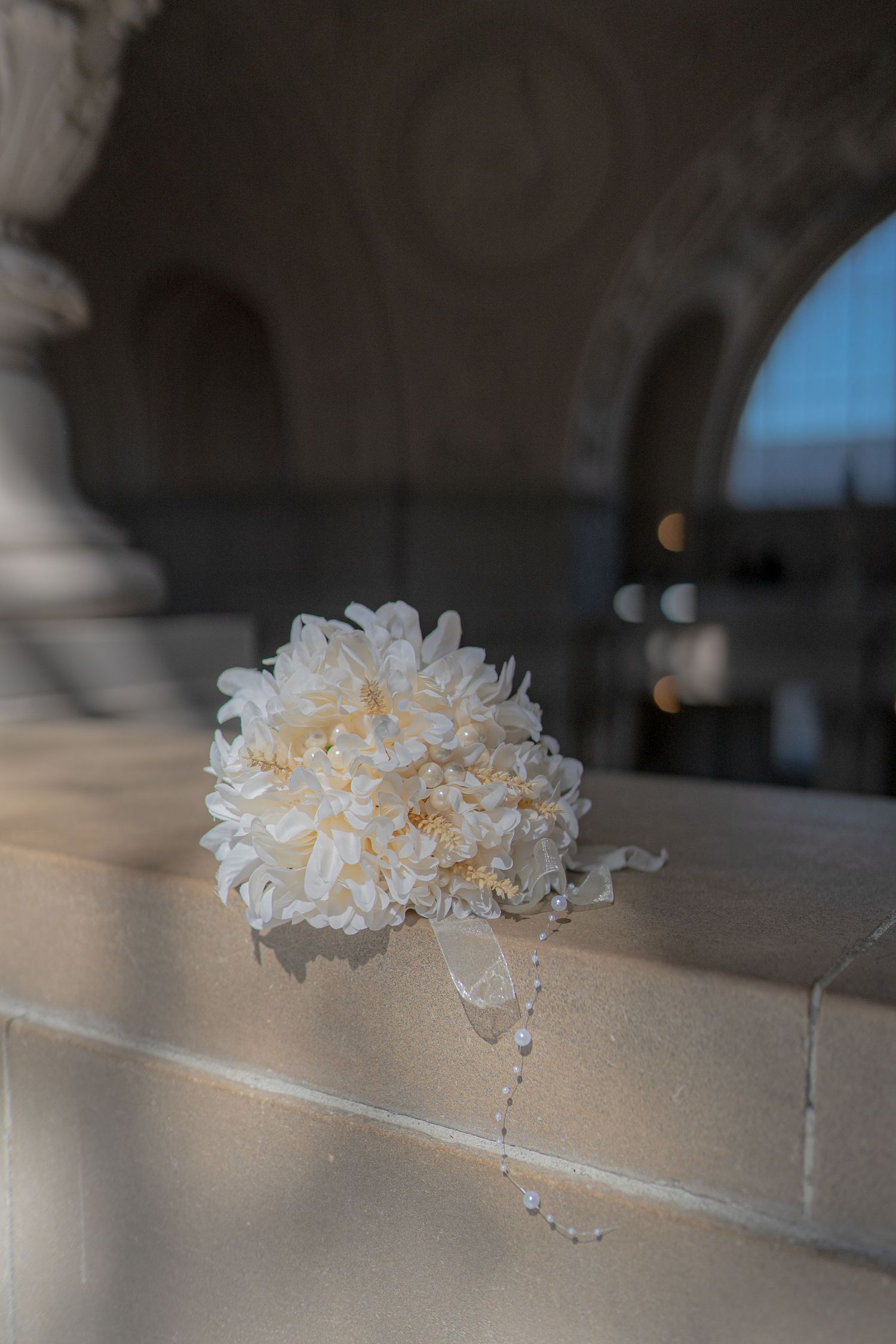 White jellyfish-like glass art sculptures arranged in a line on a light colored surface in a dimly lit space.