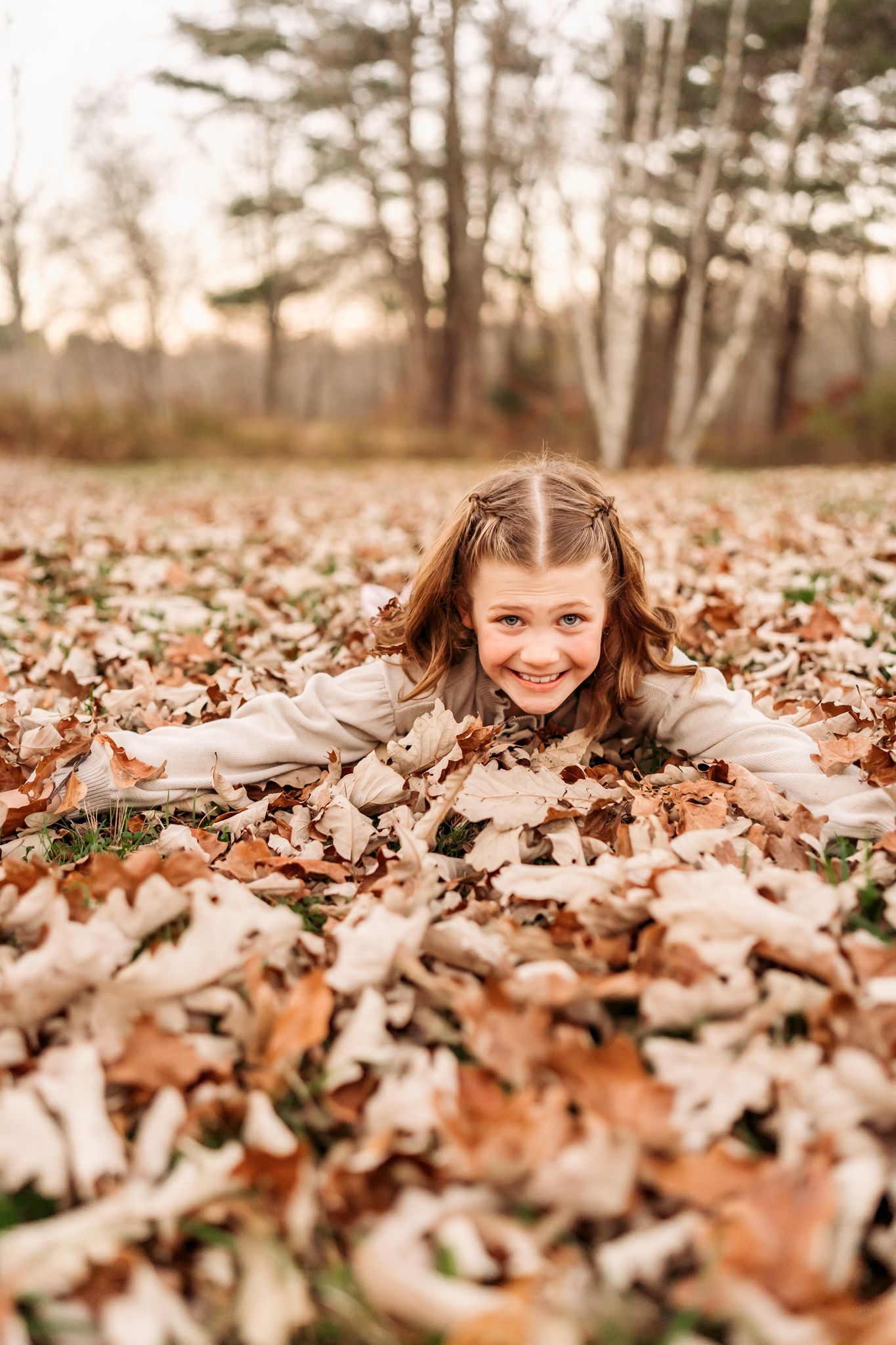 Three connected photos show a joyful autumn scene with someone peeking through scattered brown leaves on the ground.