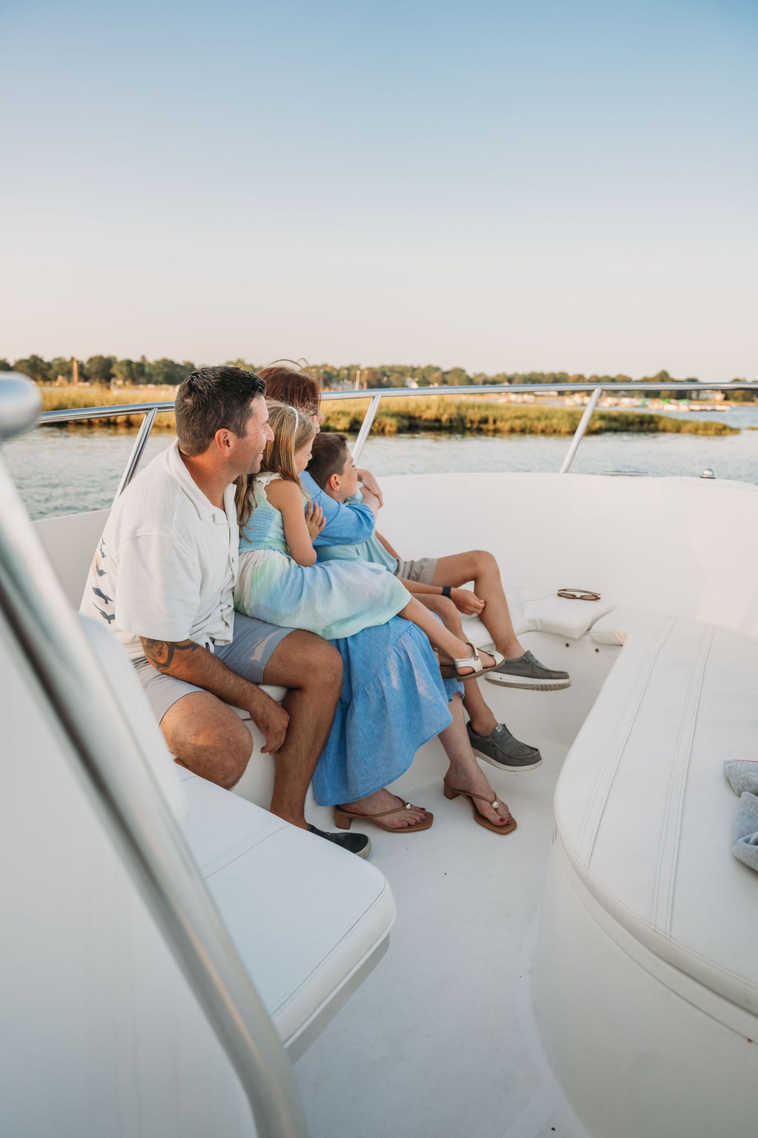 People relaxing on a boat deck during a peaceful sunset cruise along the waterfront.