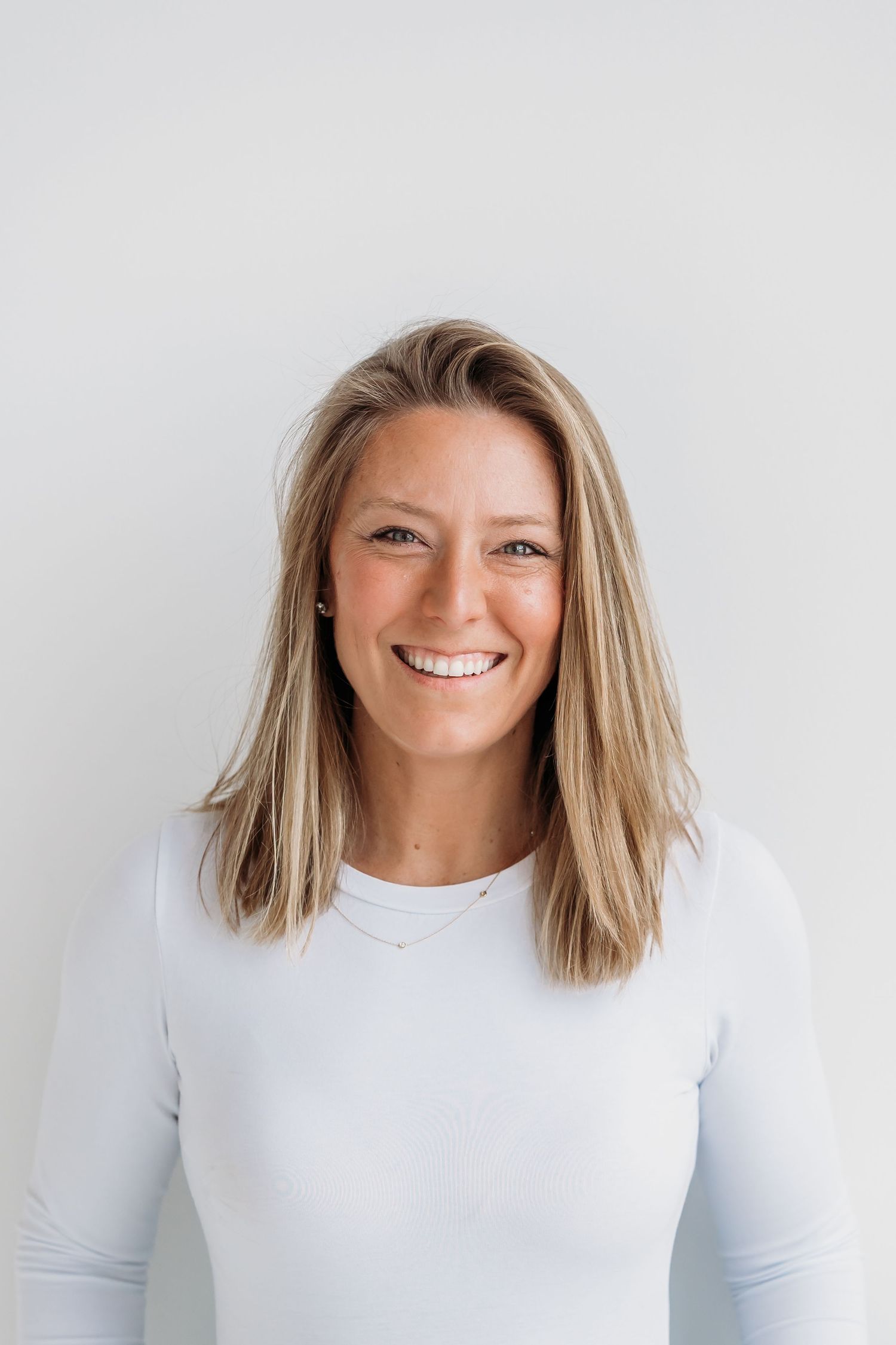 A series of four headshots showing a person with shoulder-length blonde hair wearing a white top against a light background.