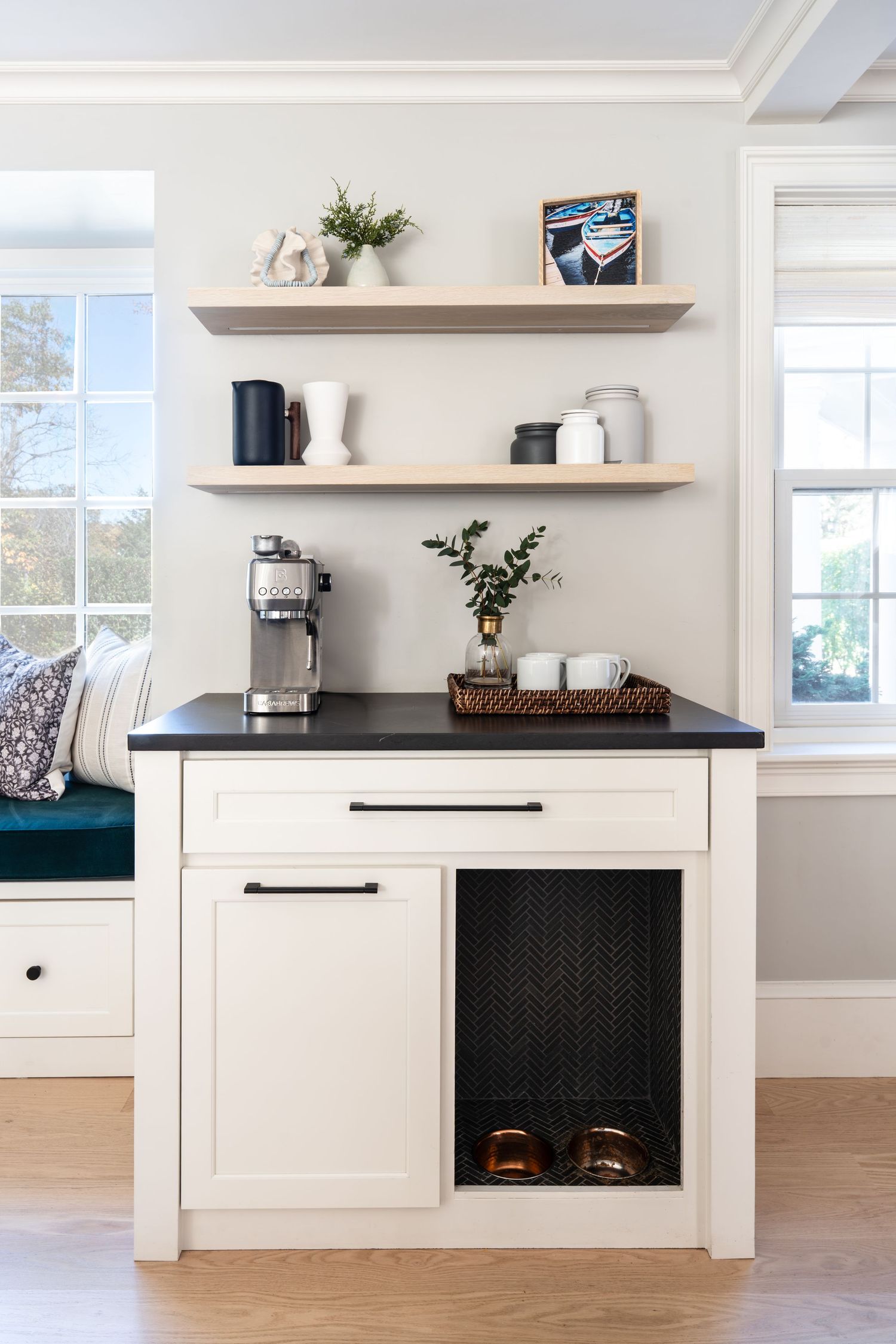 Modern white kitchen cabinets with black mesh panels and floating shelves create a clean, contemporary design aesthetic.