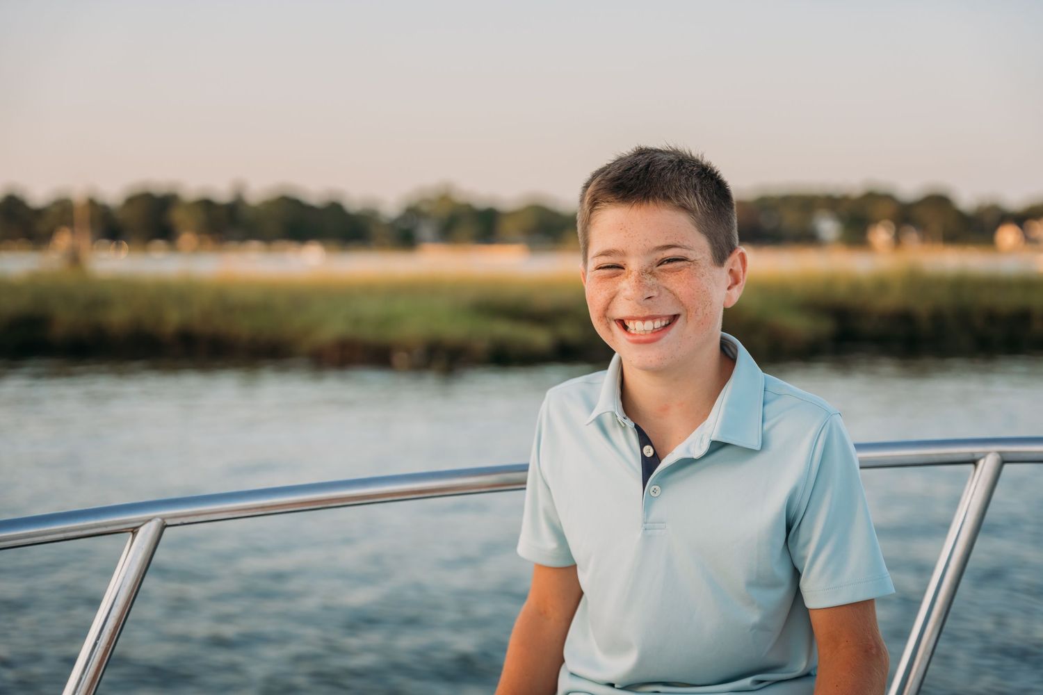 Person enjoying a sunny day out on a boat while smiling and relaxing on the water.