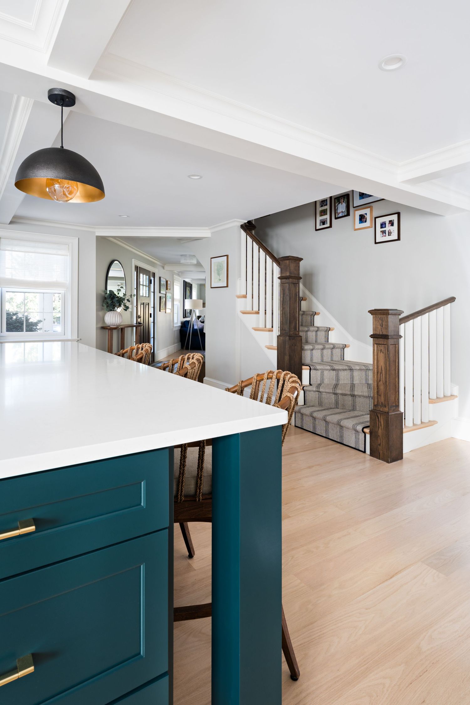 Modern staircase and hallway with teal built-in storage cabinets and light hardwood flooring in contemporary home design.