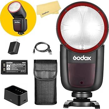 Close-up view of various black camera flash accessories and lighting equipment arranged on white background.