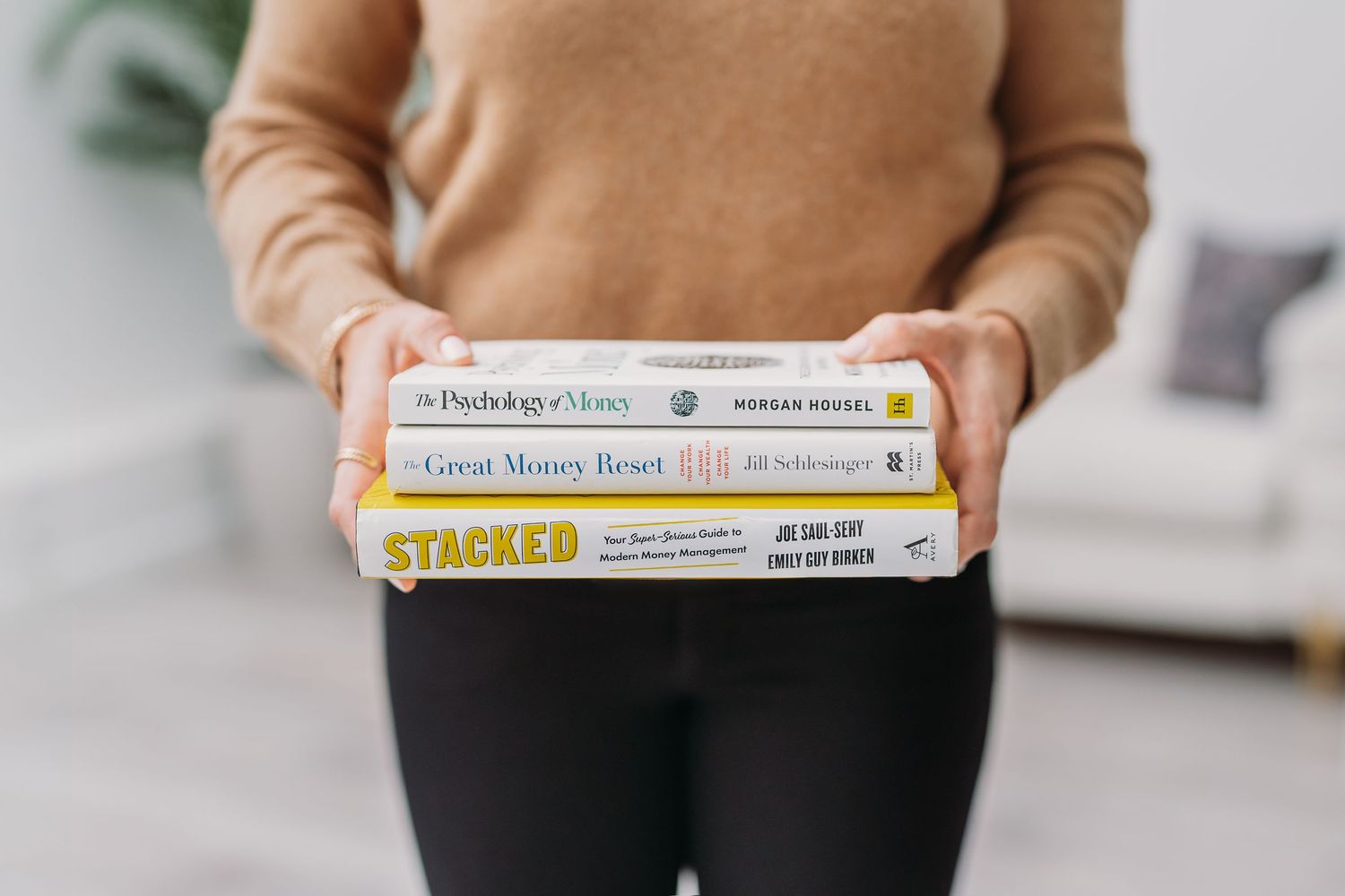Stack of cookbooks with yellow and white covers displayed on a light colored surface.