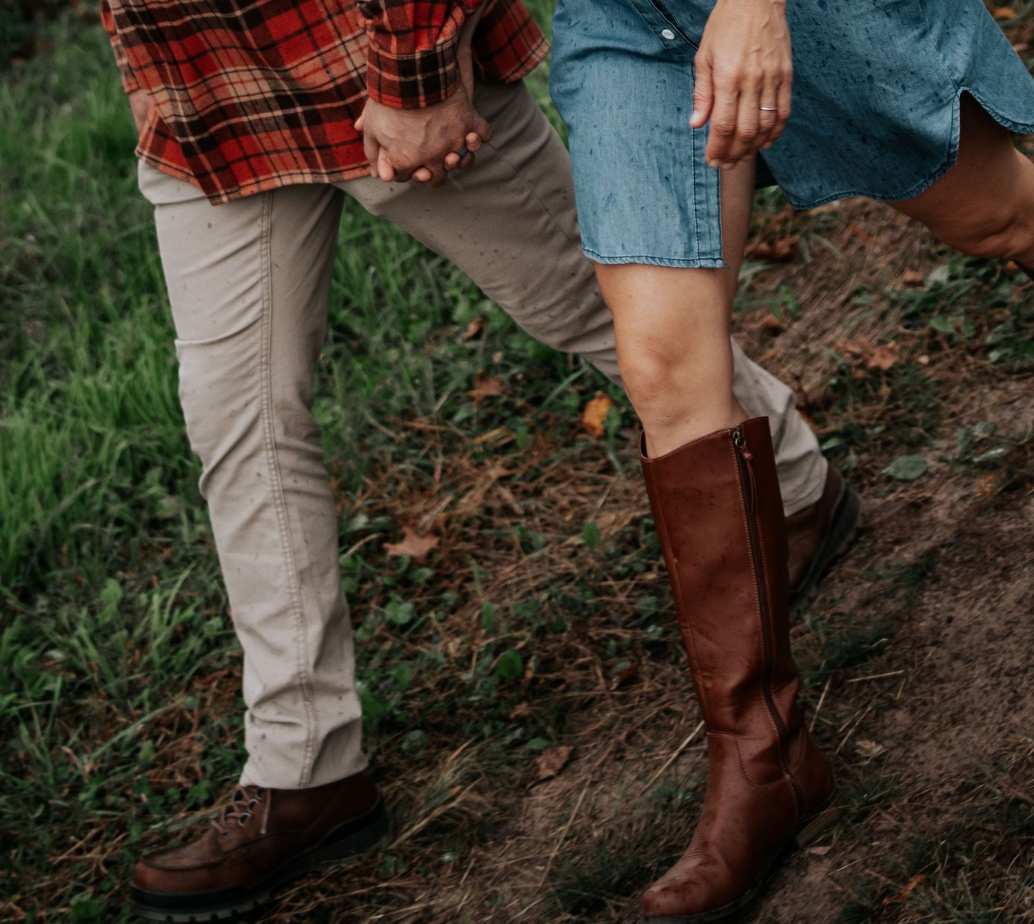 A series of boots walking through dirt and grass in a garden setting.