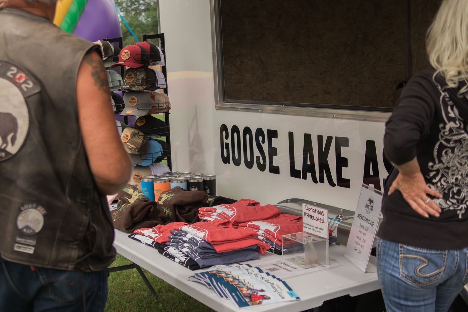 Merchandise display table at Goose Lake event with vendor selling items.