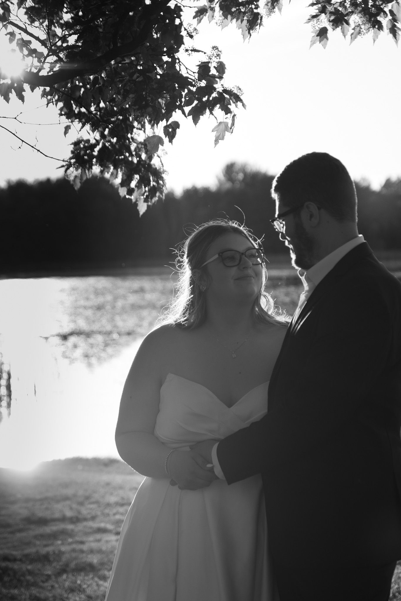 A romantic wedding photo sequence showing a couple embracing silhouetted against a bright sunset by a lake.