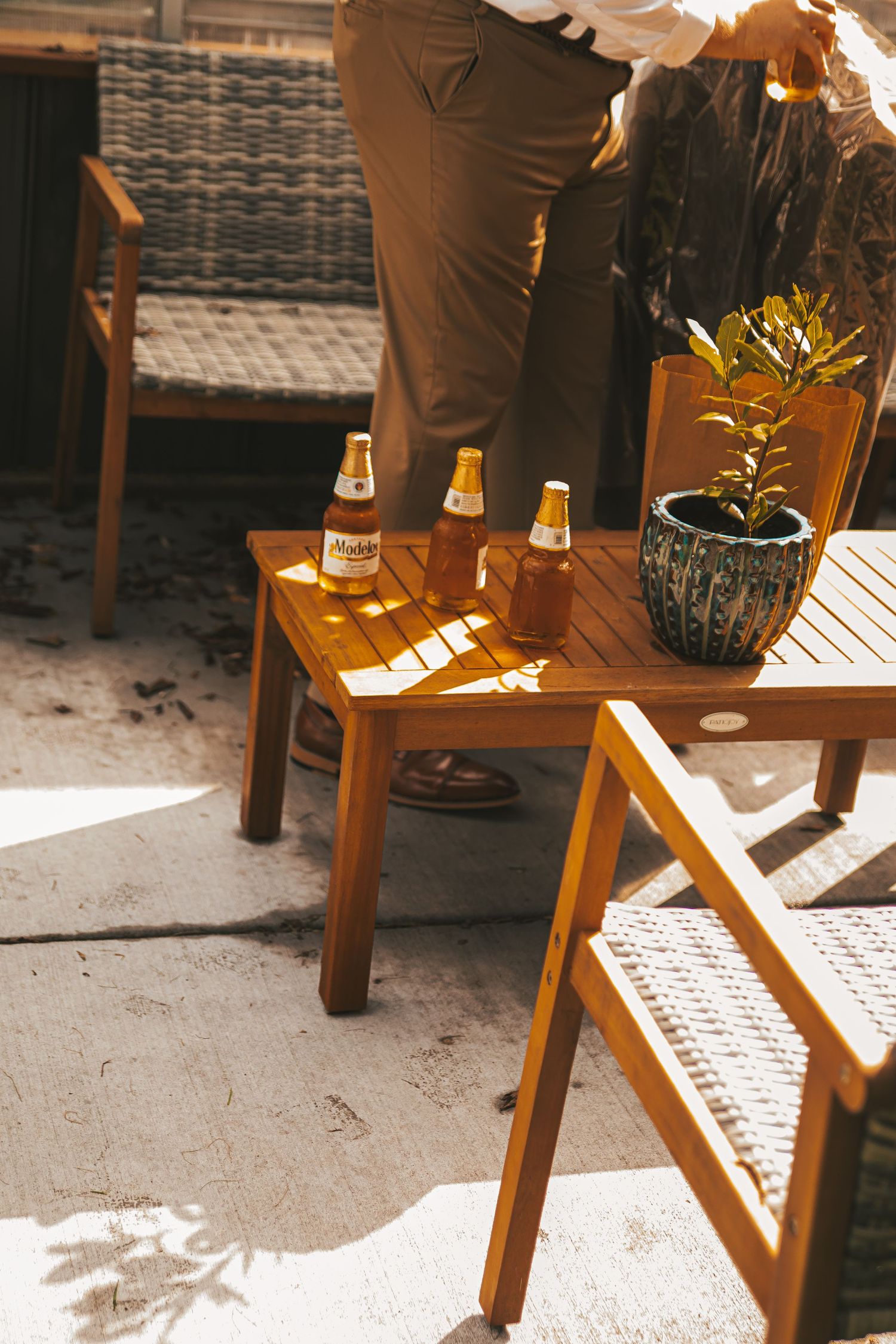 Wooden folding chair casting dramatic shadows on concrete floor in warm sunlight.