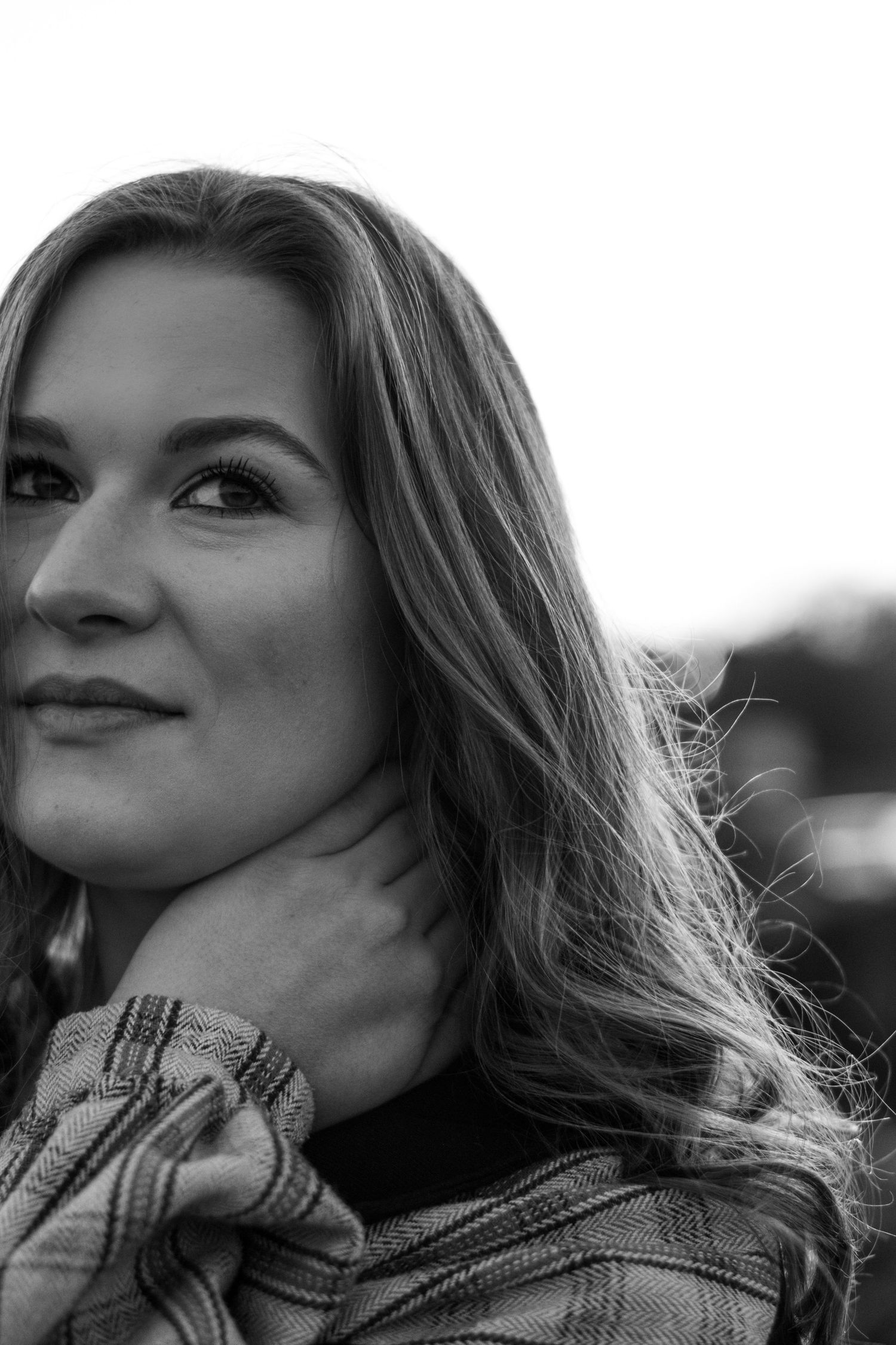 A series of black and white portraits showing a person with long hair wearing a plaid shirt in various poses.
