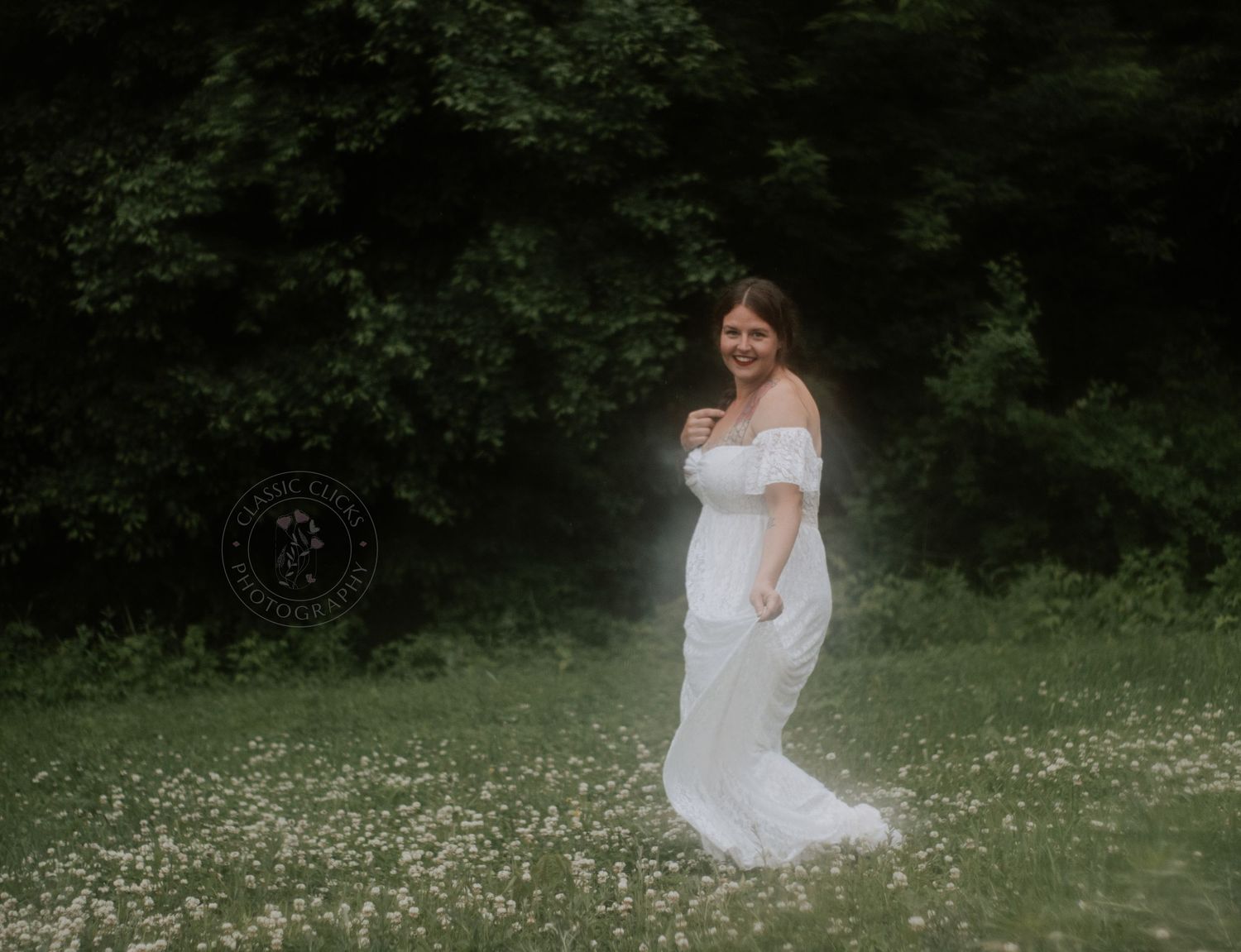 Woman in white dress twirling through flowering meadow on summer day.