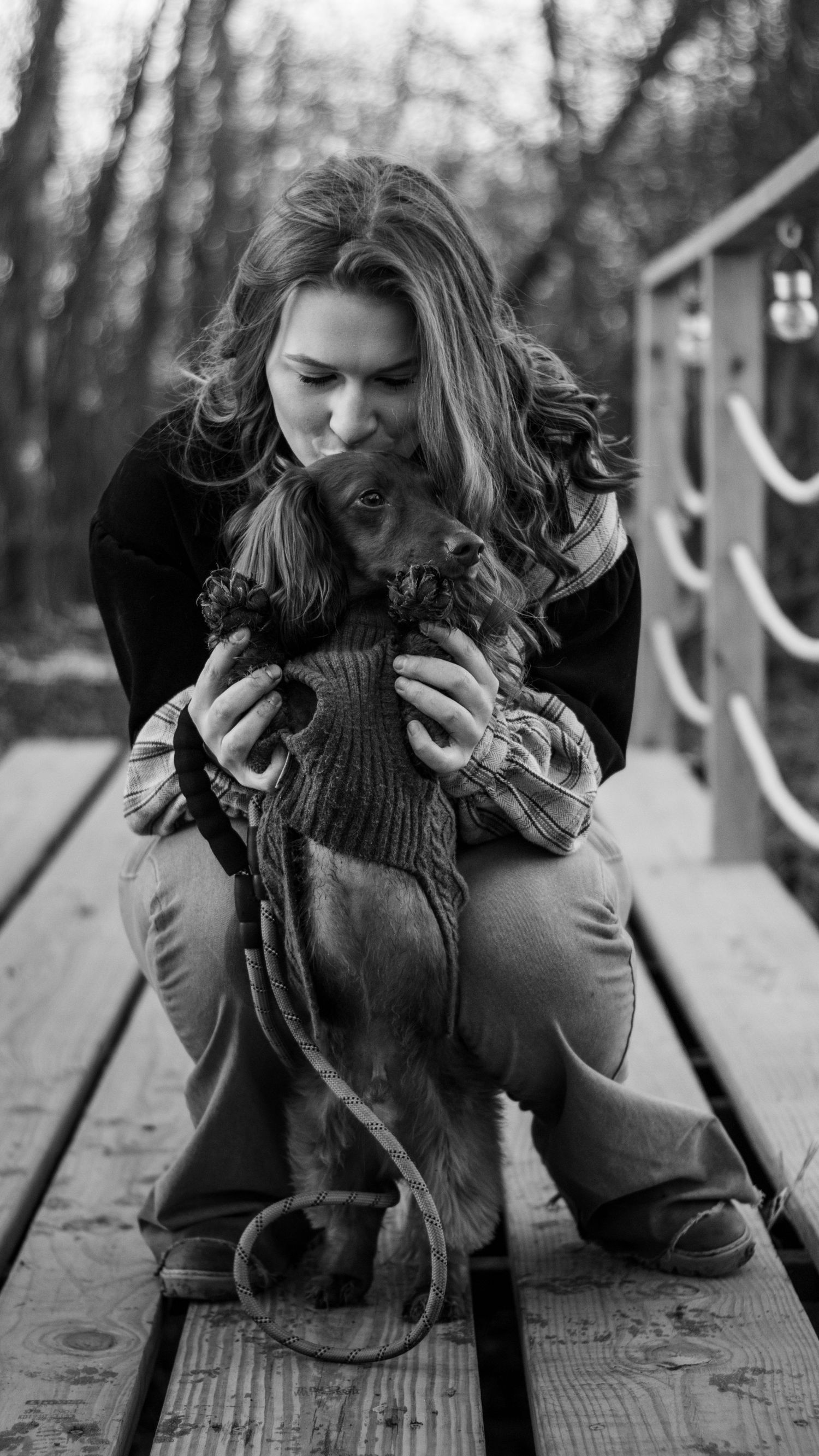 A series of black and white photos showing tender moments between someone and their dark-colored dog.