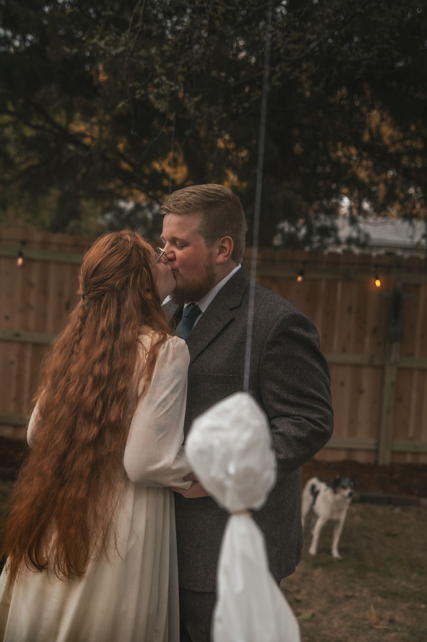 A romantic outdoor photo sequence shows a couple in wedding attire sharing tender moments at dusk with a white dog in background.