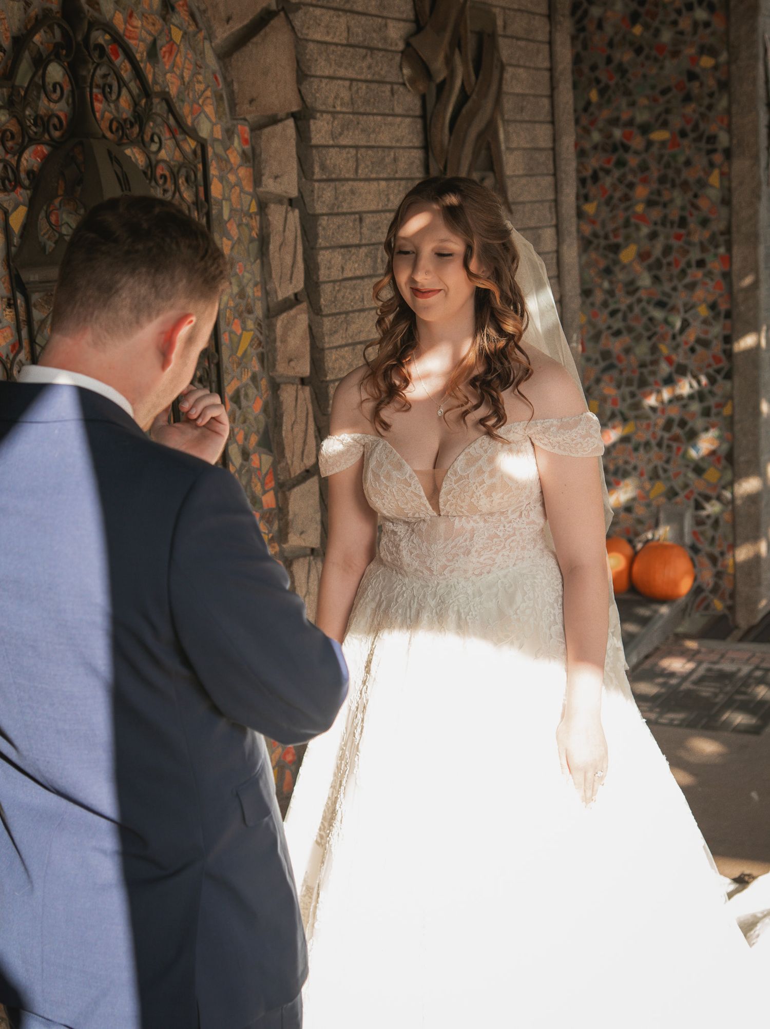 A couple shares an emotional first look moment at their wedding with the bride wearing a beautiful off-shoulder gown.