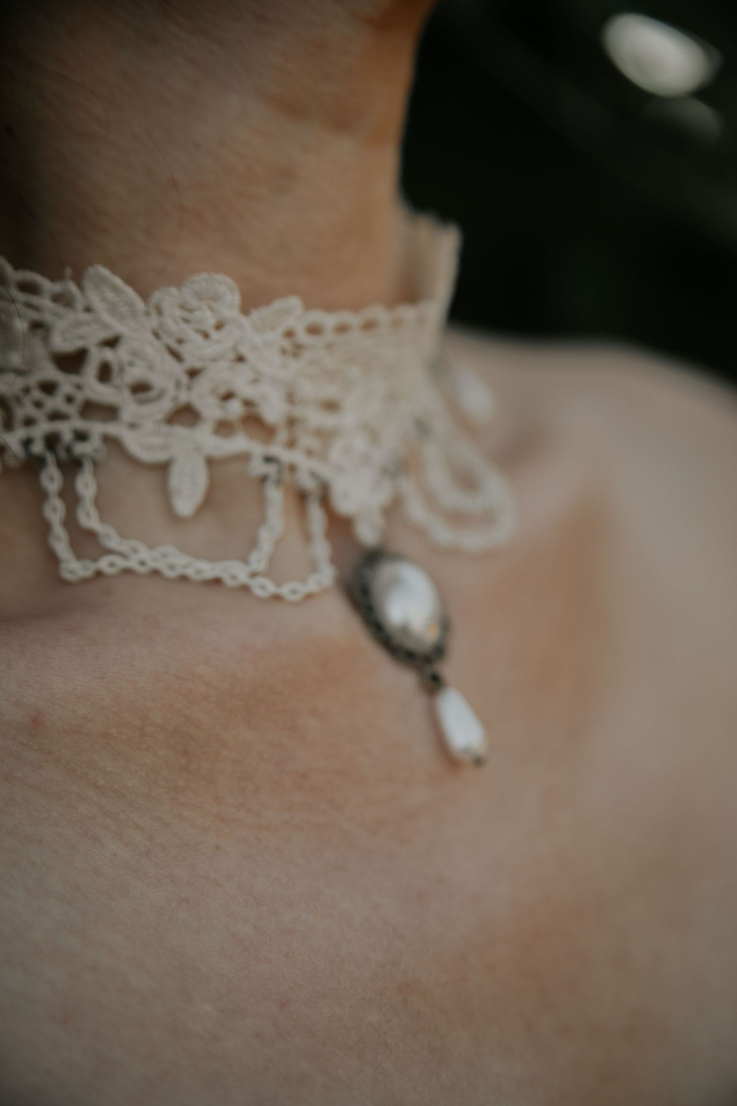 Close-up macro shots of delicate white lace details and pearls on a wedding dress or bridal accessory.