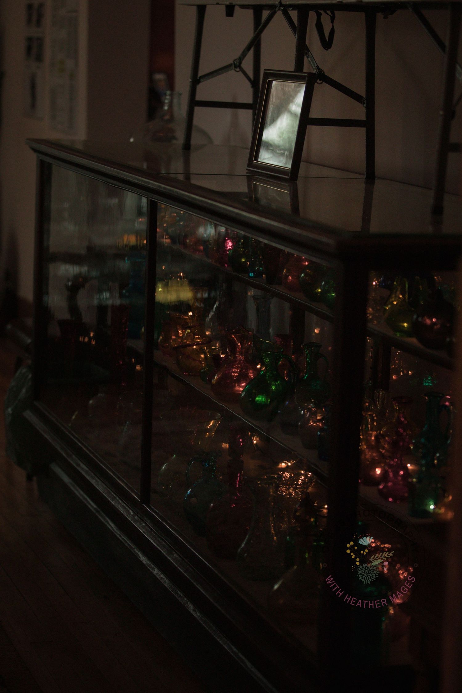 Dimly lit display of holiday lights and decorations creating a festive glow in a dark interior space.
