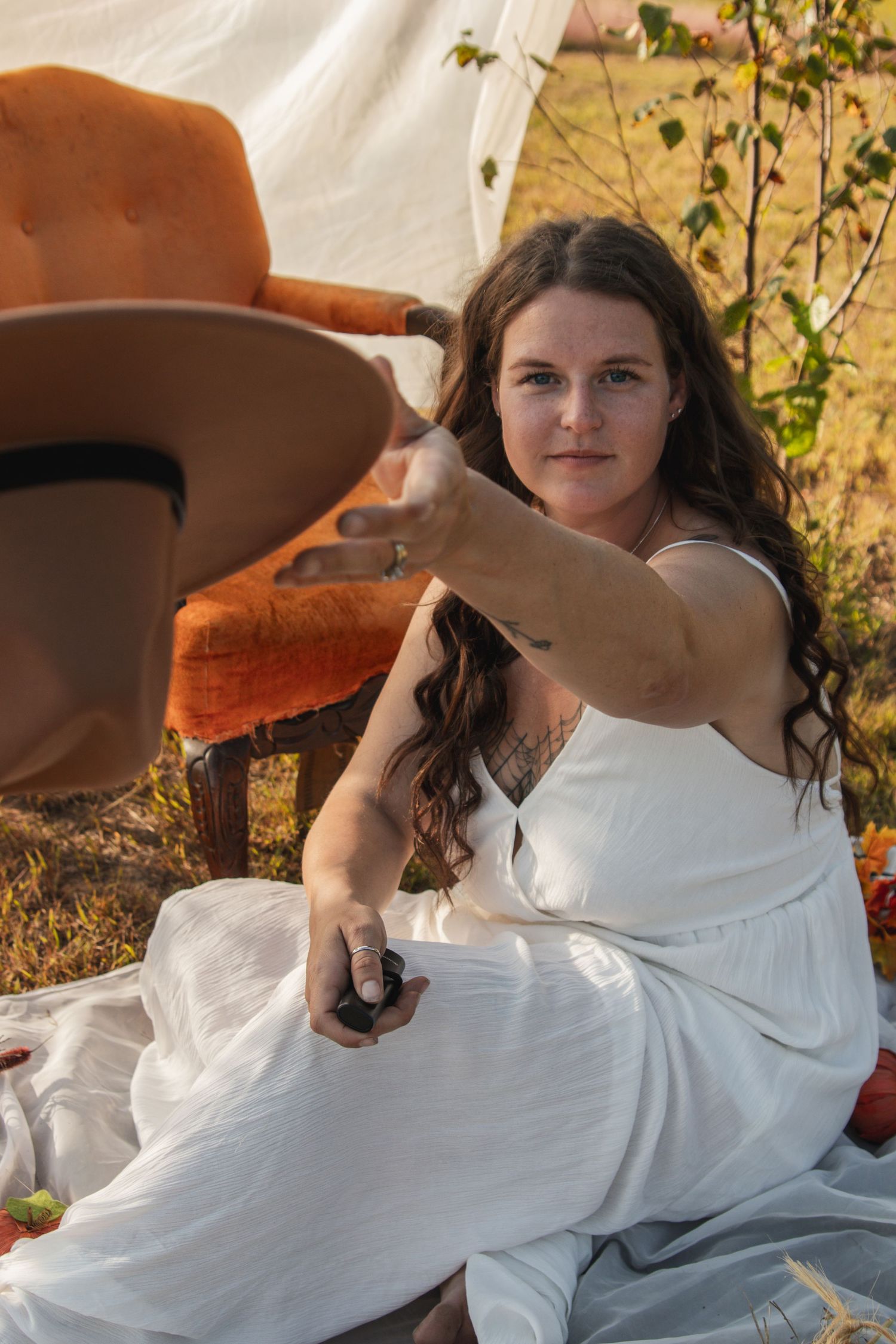 Person in white dress poses outdoors with autumn foliage and brown hat visible in series of connected photos.
