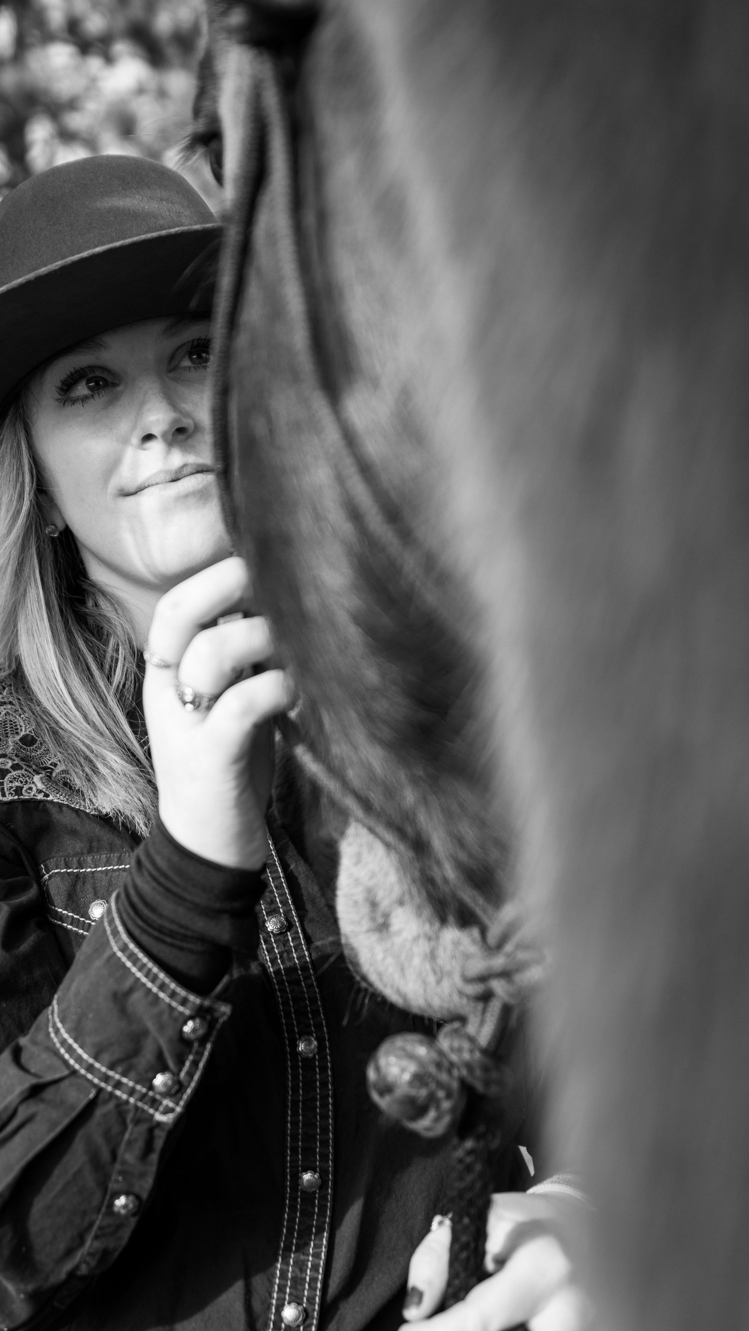 An intimate black and white photograph showing a horse and rider sharing a tender moment together.