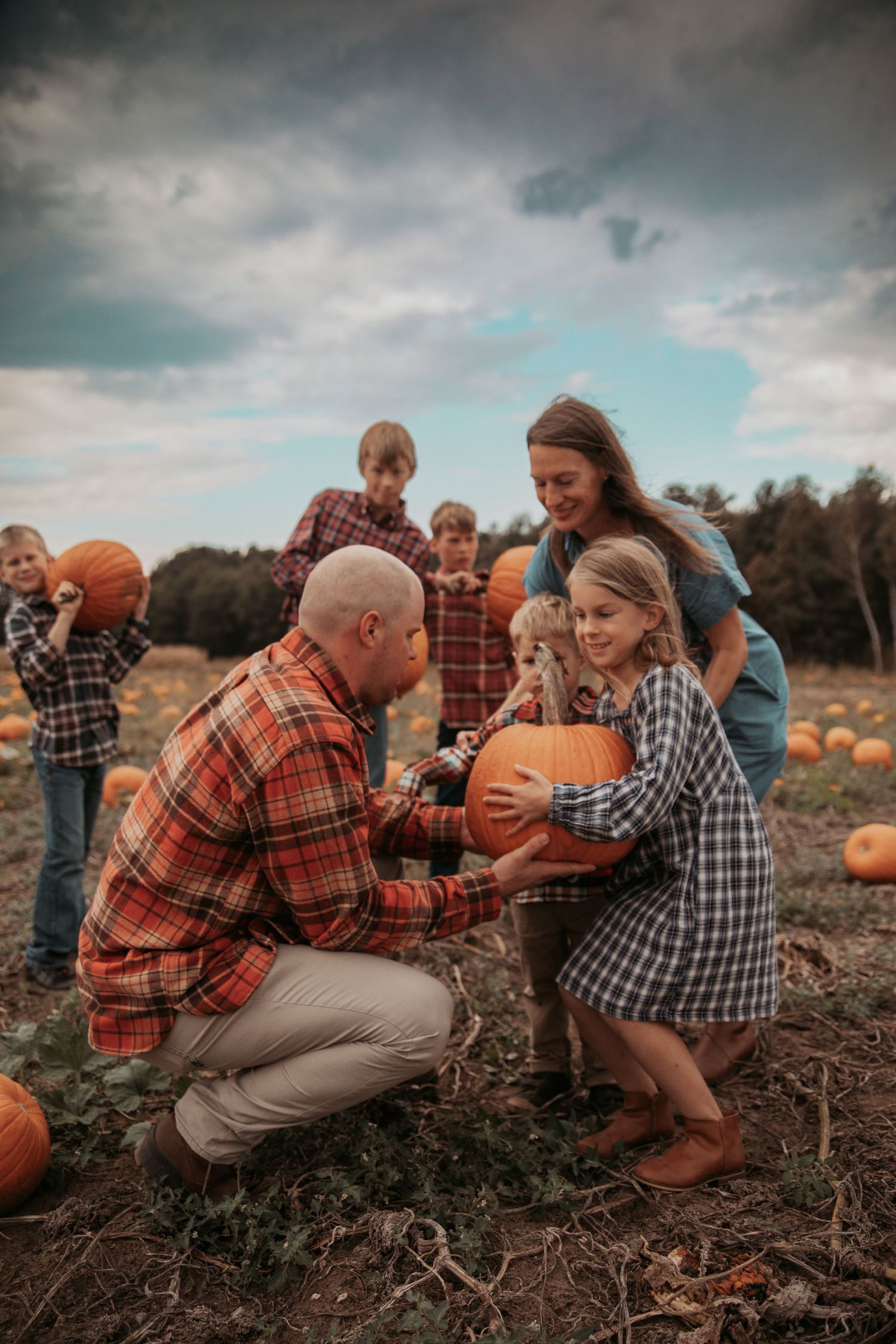 A playful sequence of candid moments at a pumpkin patch with people interacting and having fun on an overcast day.