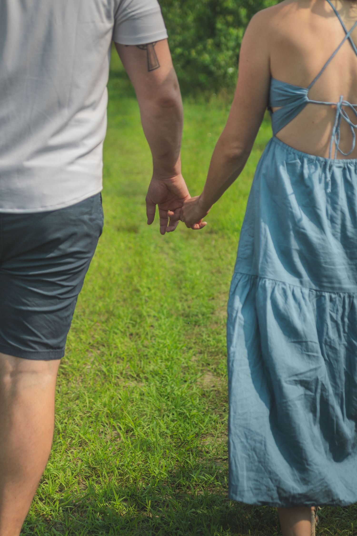 Close-up view across multiple scenes showing two people in casual clothes holding hands on green grass.