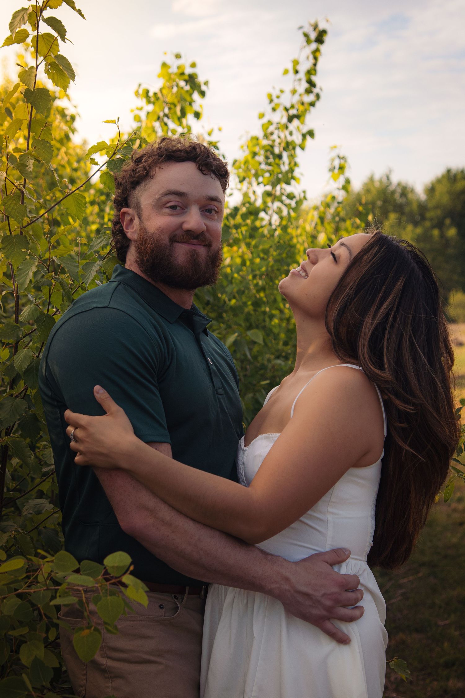 Couple embracing in romantic photoshoot sequence among vineyard rows at golden hour.