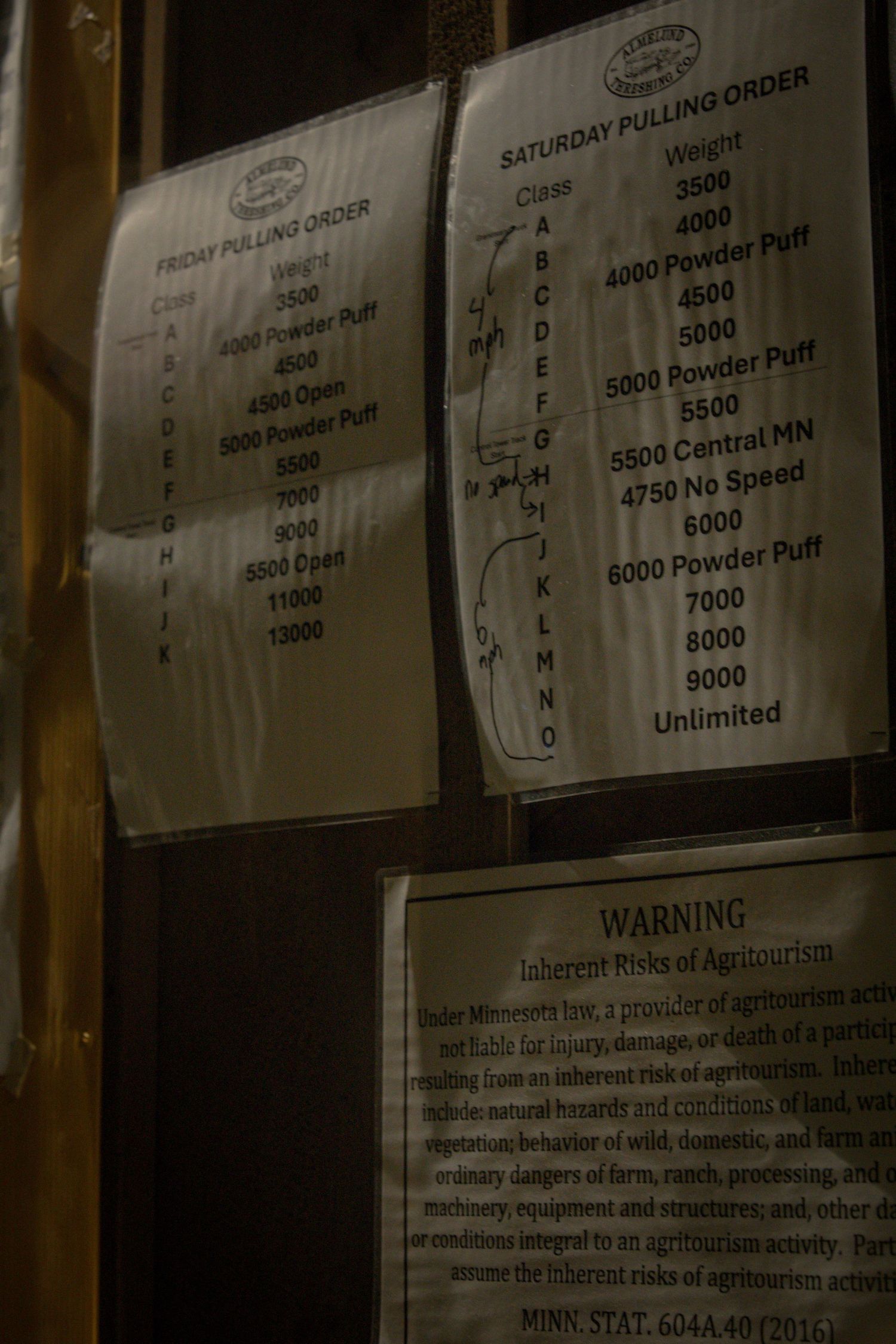 Close-up of a bulletin board displaying competition rules and class listings with text visible.