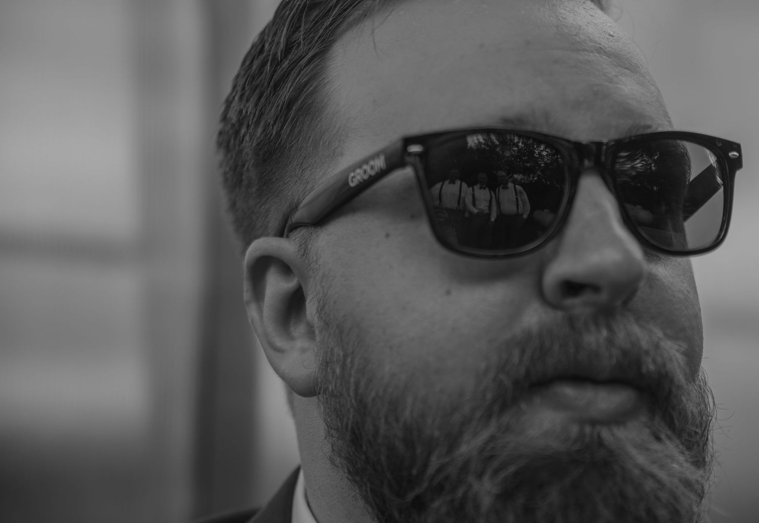 A black and white photo series showing a person in glasses and facial hair at different angles and expressions.