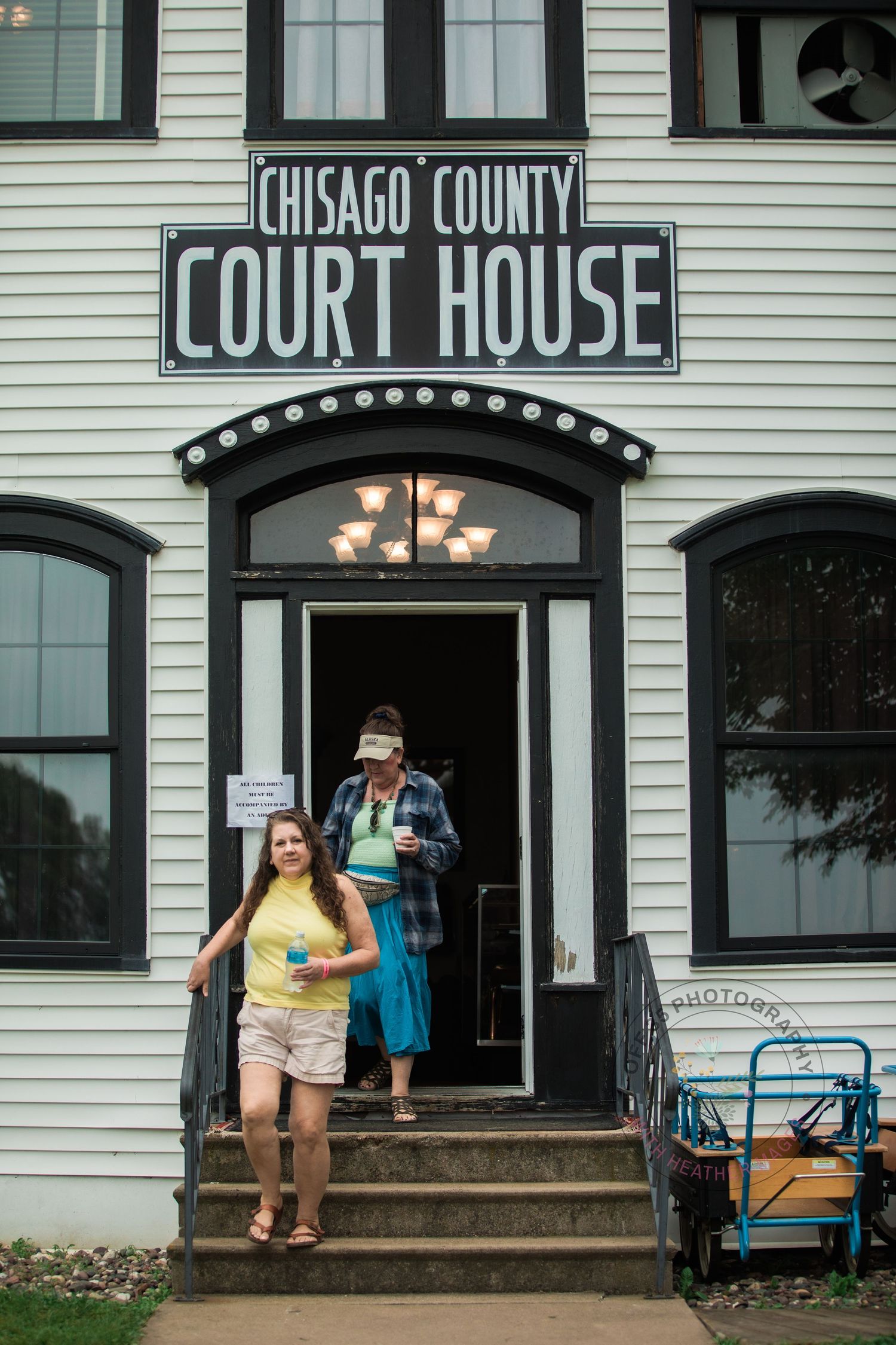 Historic white Chisago County courthouse building with steps and entrance signage.