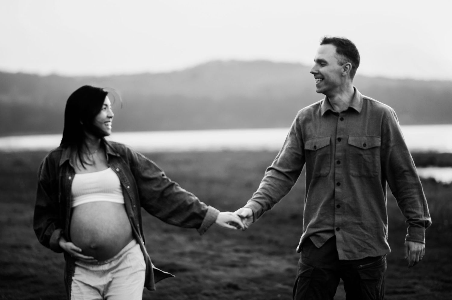 A black and white photo series showing a romantic couple walking and embracing in a scenic outdoor setting.