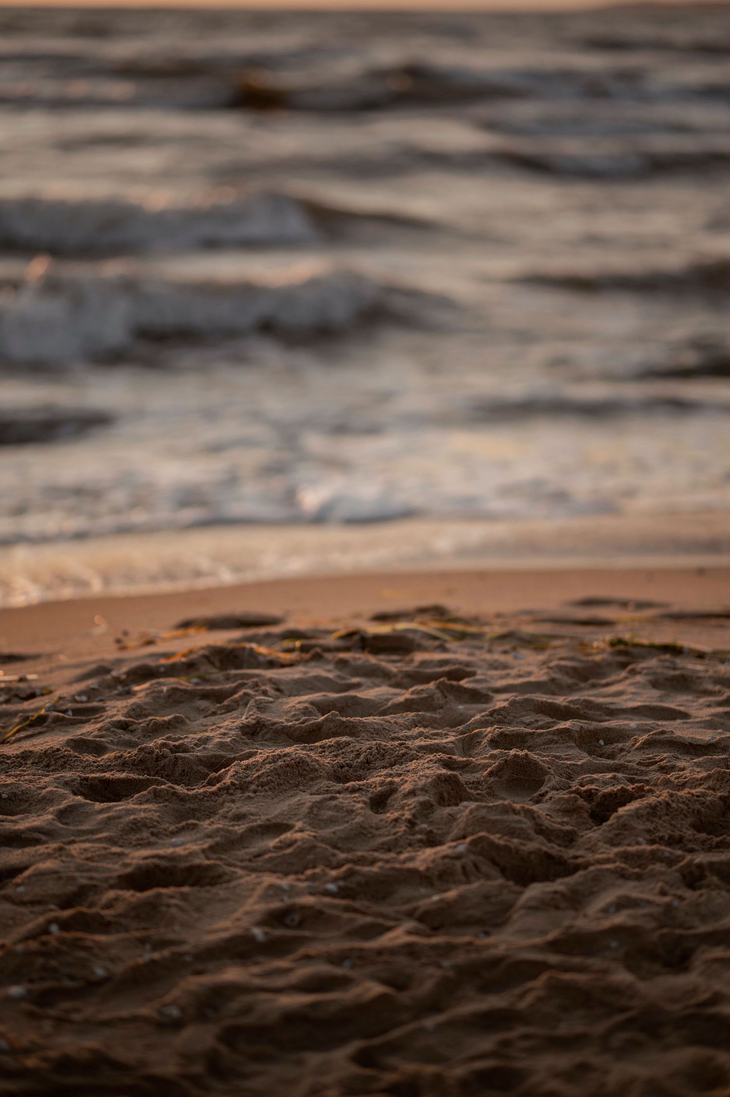 Close-up view of dark rippling ocean water with soft focus waves at sunset creating a moody seascape.